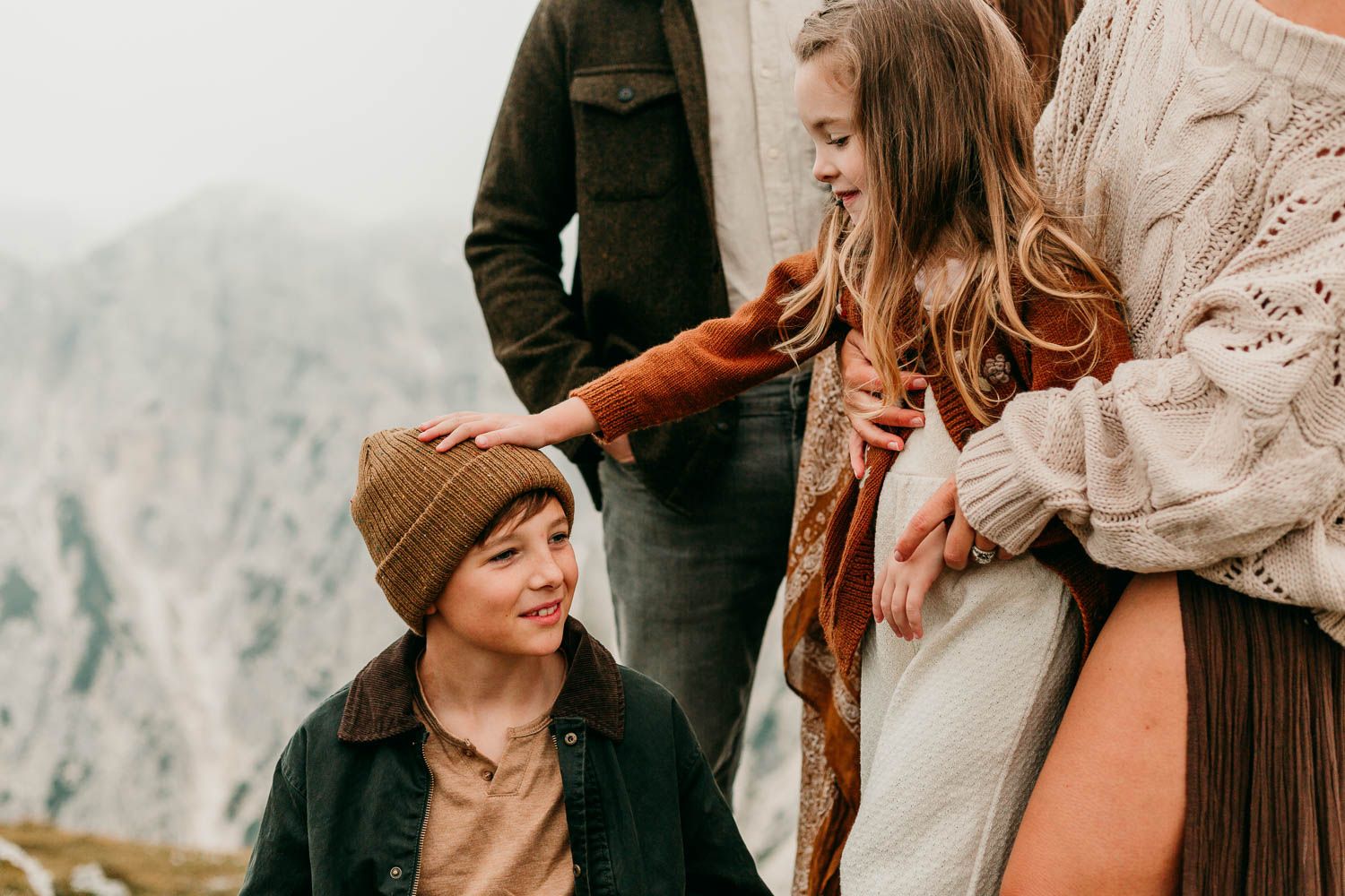 A series of intimate closeup of seattle family photos showing a couple in casual autumn attire against a misty mountain backdrop.