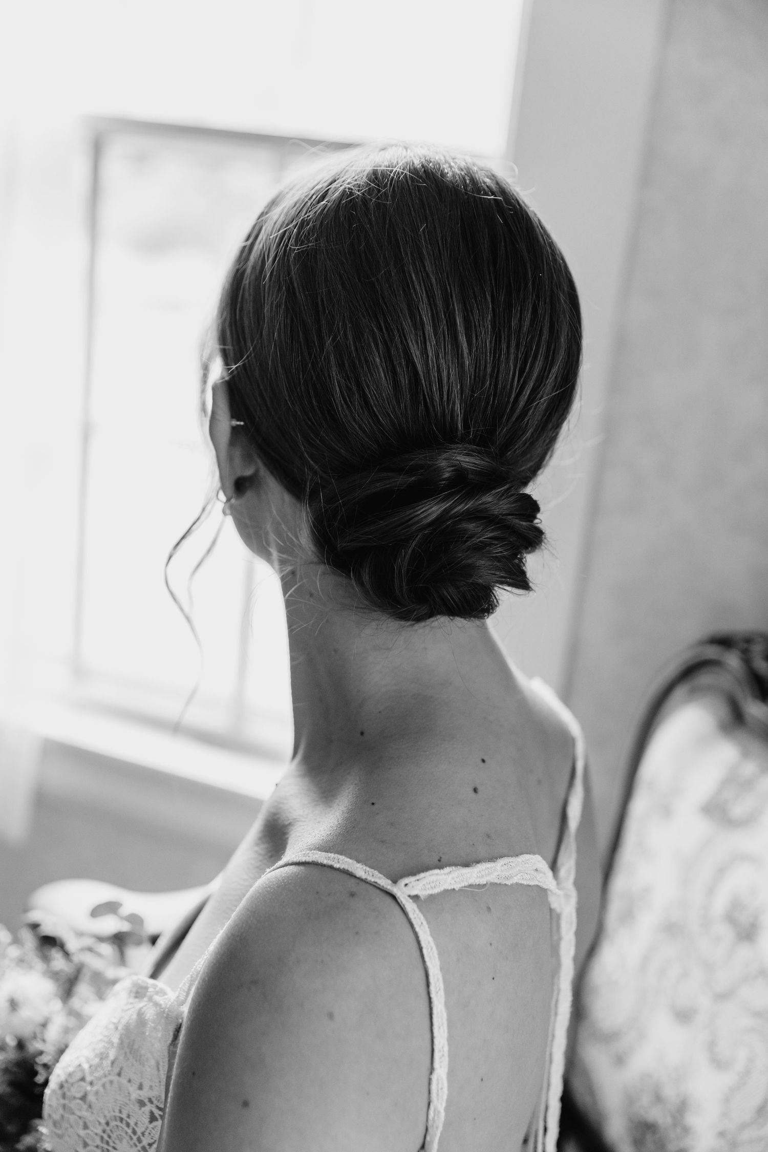 Black and white image of bride gazing out window at Kitz Farm in Strafford, NH