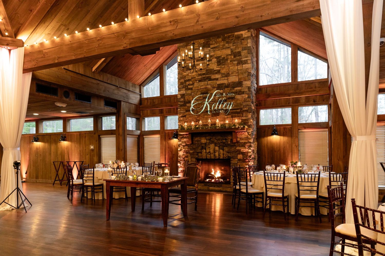 Birch Wood Vineyards Wedding Derry NH indoor reception area fireplace with beams and drapes