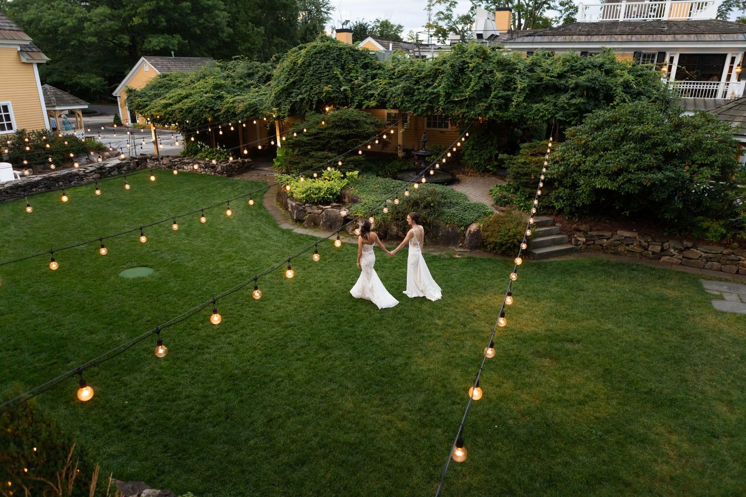 Bedford Village Inn wedding ceremony area Bedford NH string lights garden courtyard ceremony cocktail hour and reception space two brides