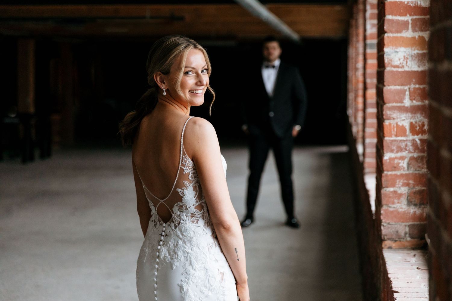 Venues at the Factory wedding Manchester NH industrial wedding bride and groom first look photo with bricks and natural light