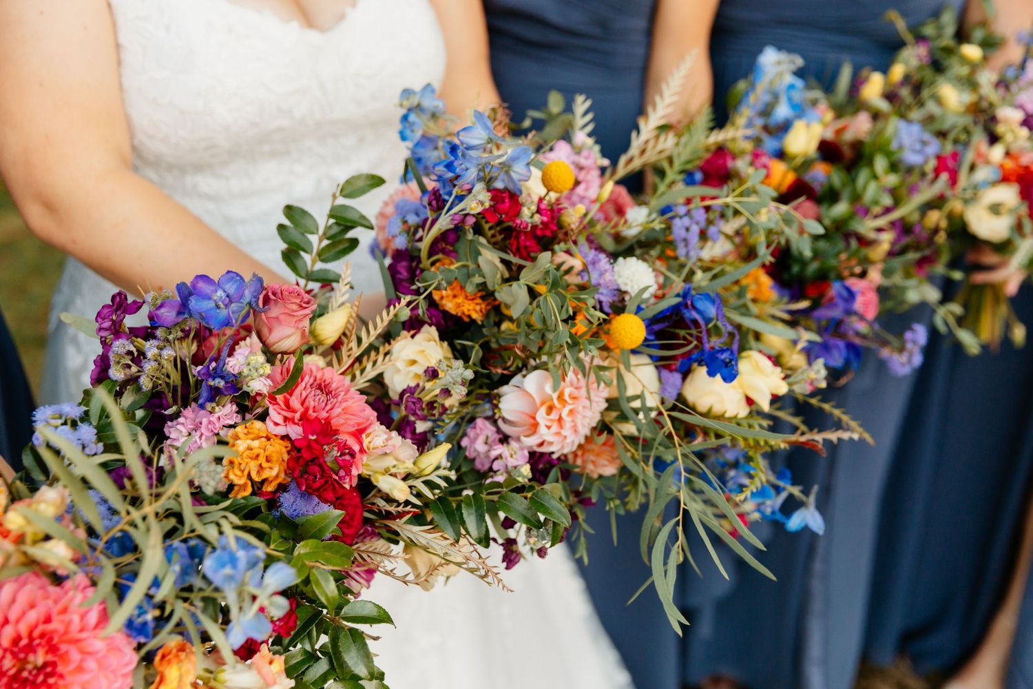 Detail shot of colorful wildflower bouquets held by bride and bridesmaids at Steele Hill Resort in Sanbornton, NH.