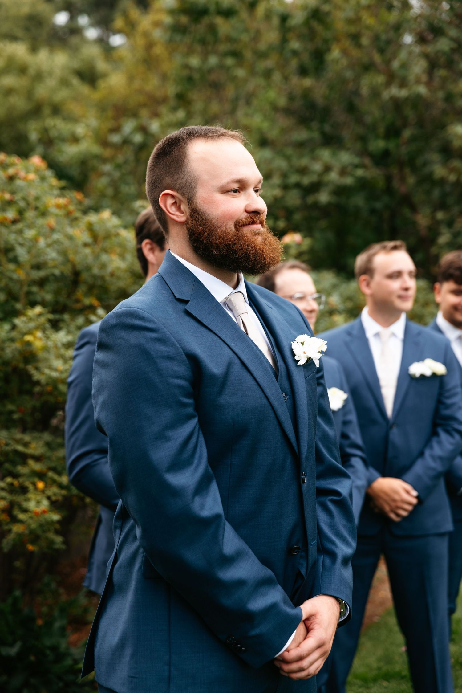 Groom in Navy suit watching bride walk down aisle at summer wedding at John Hay Estate at The Fells in Newbury, NH