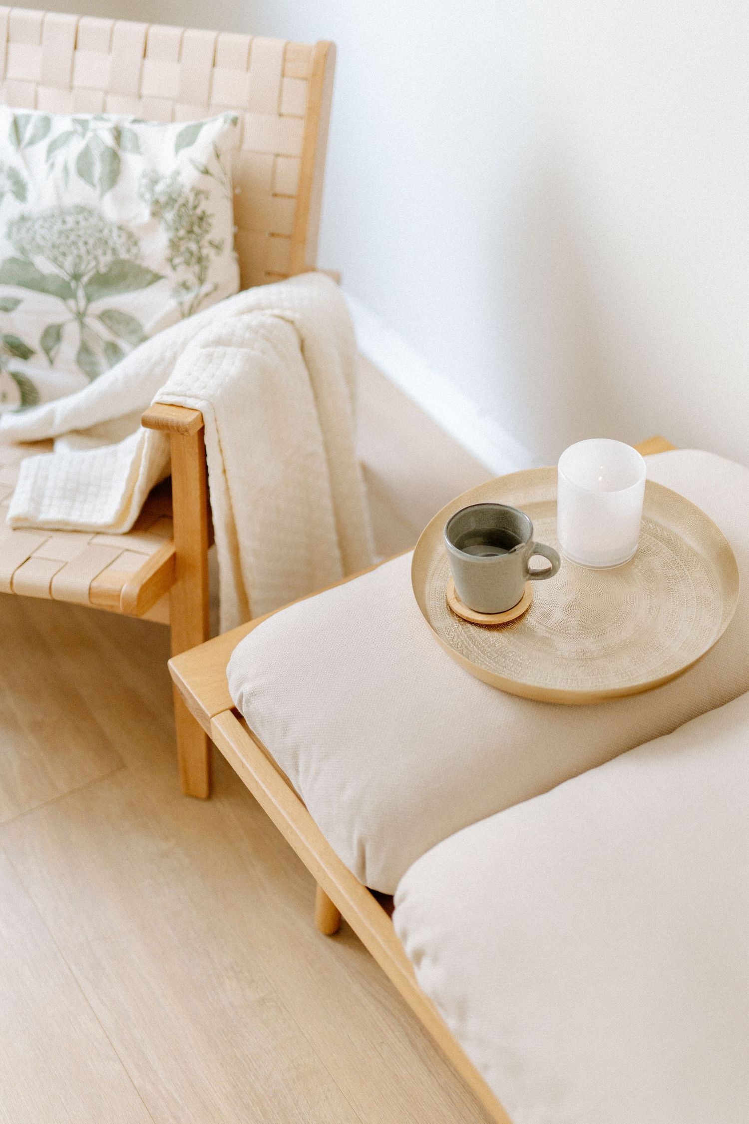 Ykstyiskohtakuva jossa näkyy sohva, nojatuoli ja astioita tarjottimella Nest for Soul- vuokratilassa Helsingin Albertinkadulta.