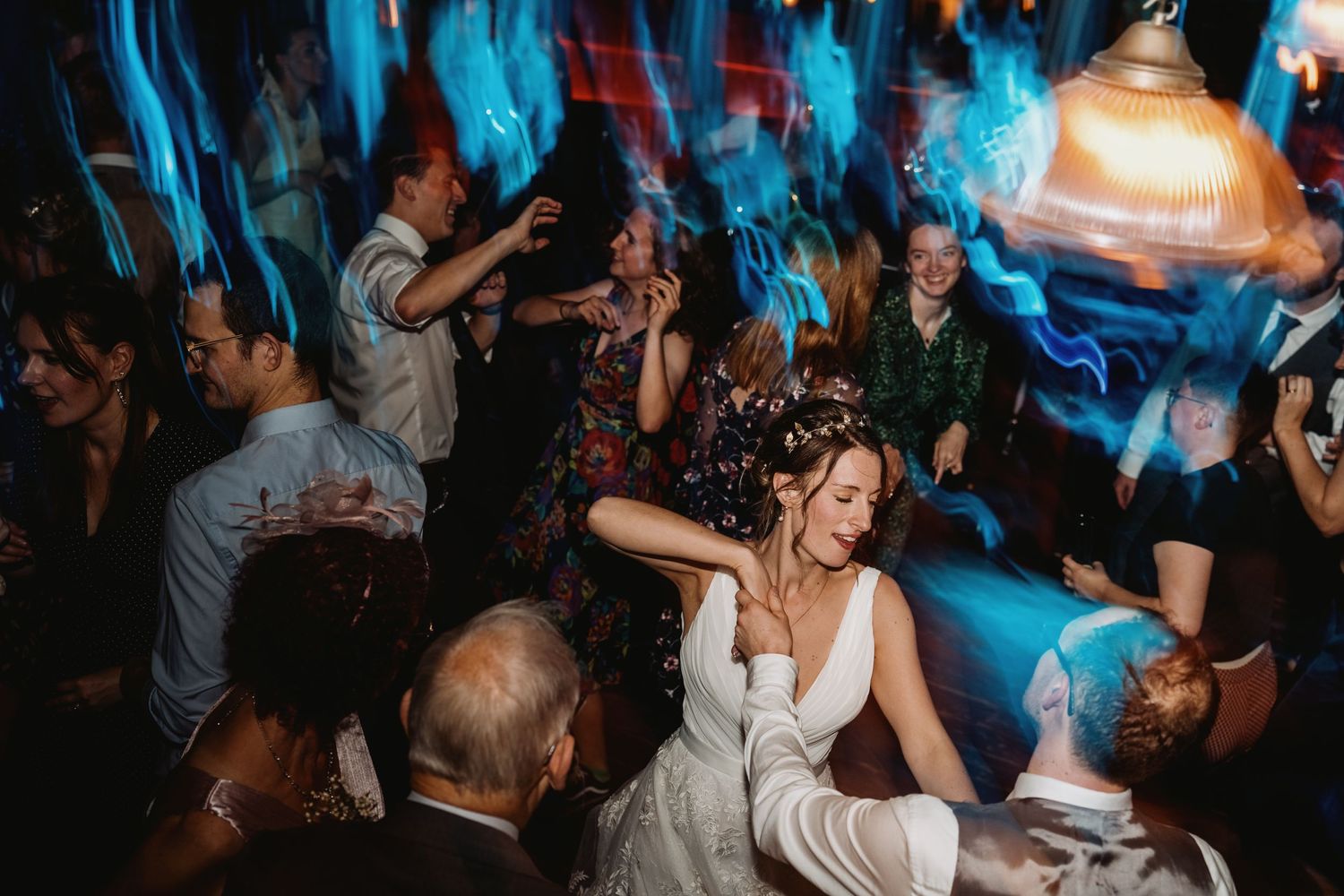Wedding reception dance party with blue lighting and celebration on the dance floor.