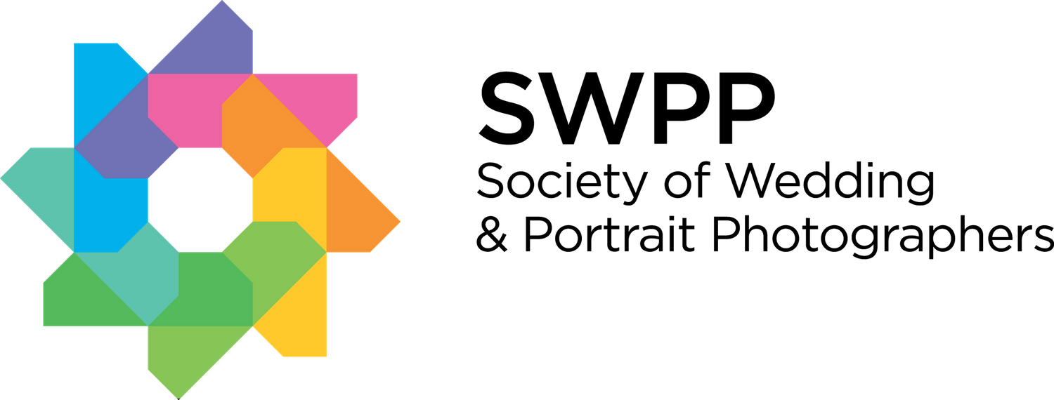 A colorful geometric star or flower shape logo design with interlocking segments in blue, pink, purple and yellow.