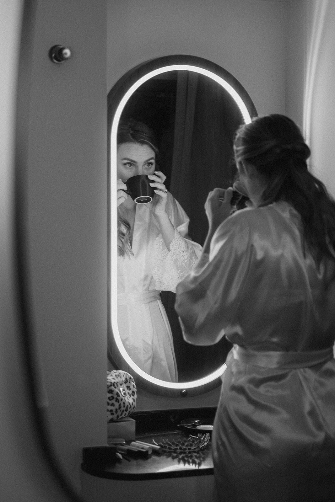 Bride sipping coffee and looking at her reflection in the mirror on the morning of her Edinburgh elopement