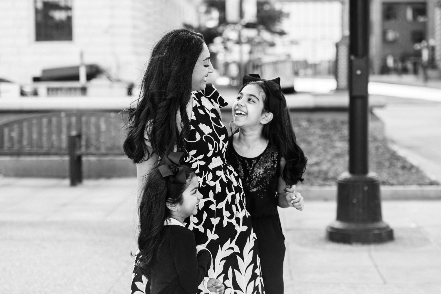 A black and white portrait captured outdoors near urban architecture.