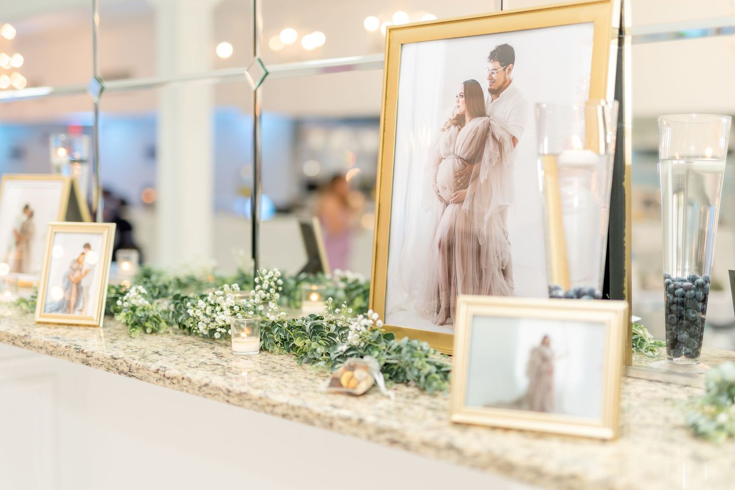 Elegant framed wedding photos displayed with greenery decor and soft lighting.