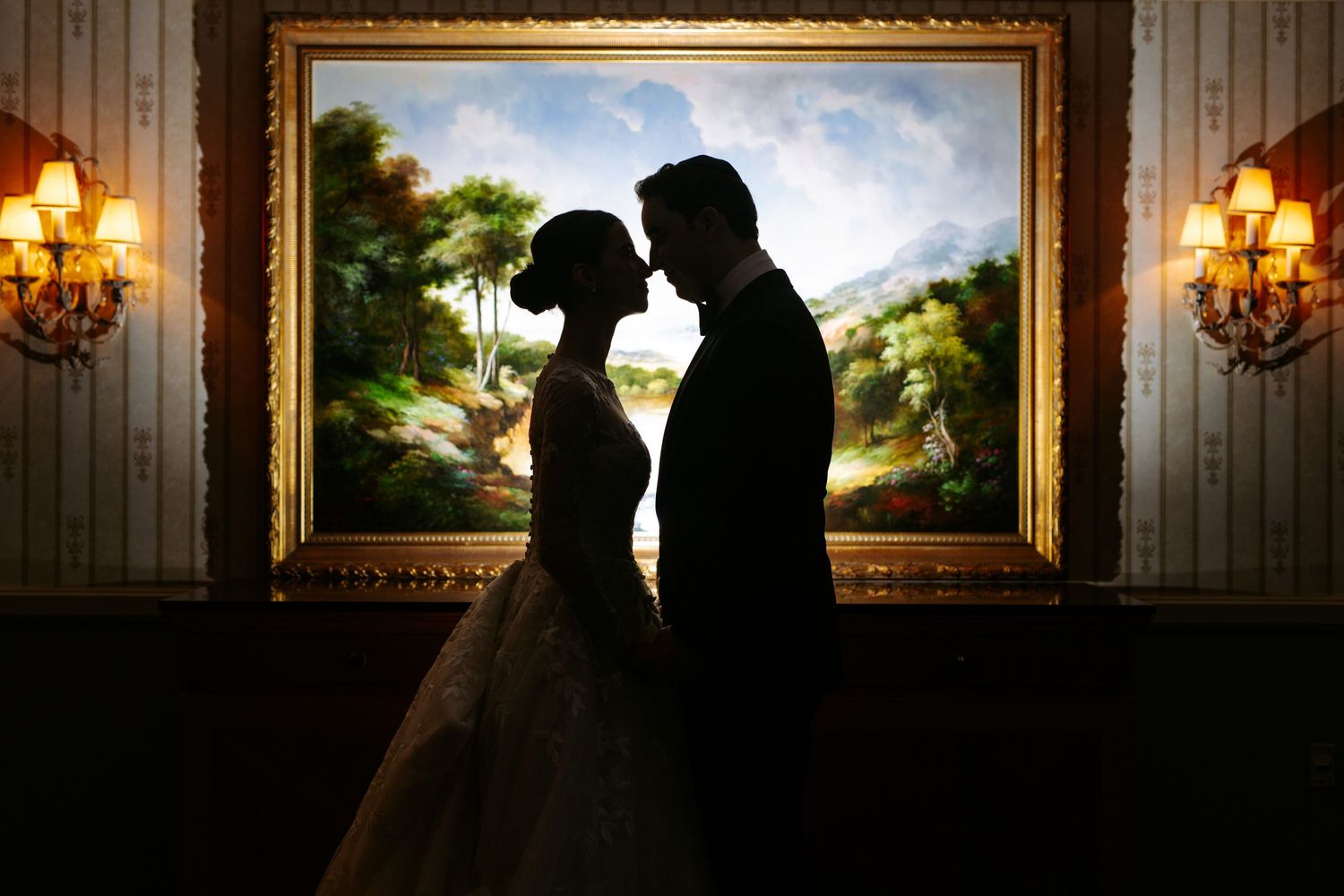 Romantic silhouettes of a couple against warm interior lighting and framed artwork.