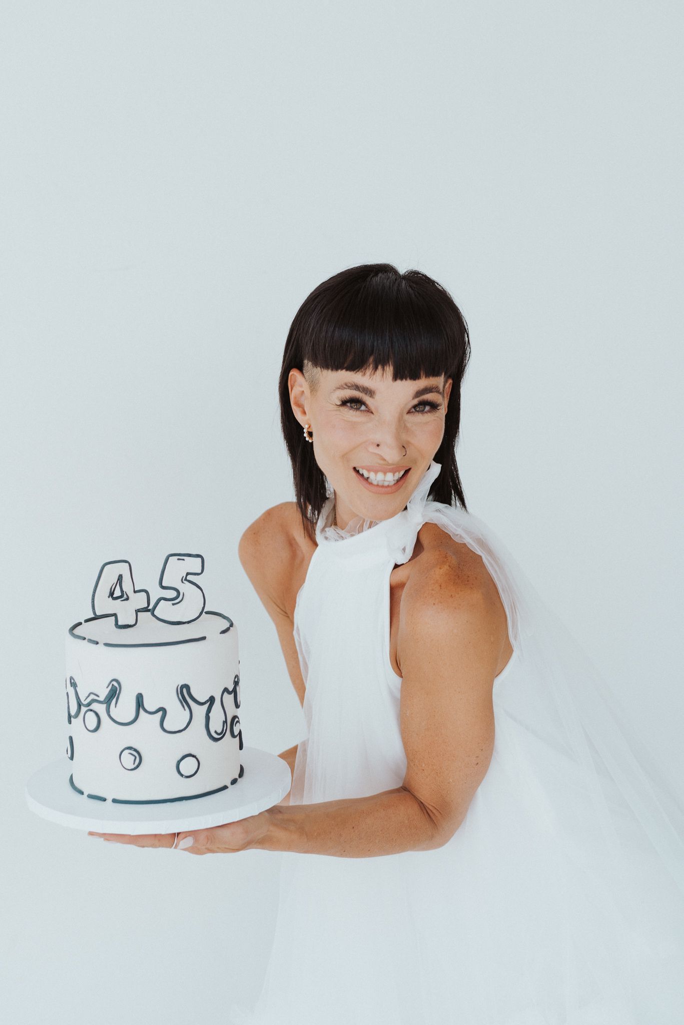 Minimalist sketch of birthday cake with number 45 drawn on white background.