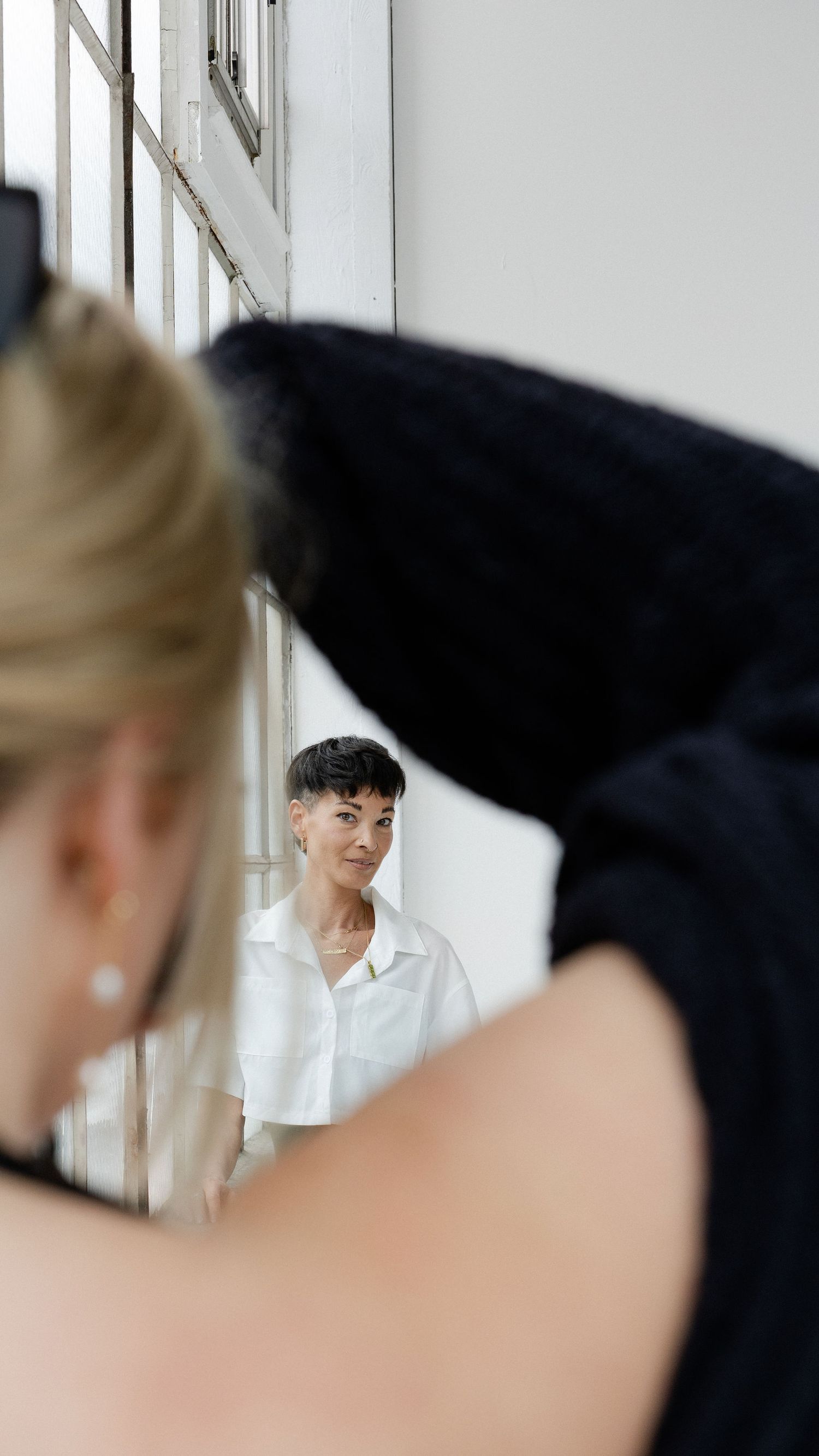 Creative mirror reflection shot showing profiles in black and white interior setting.