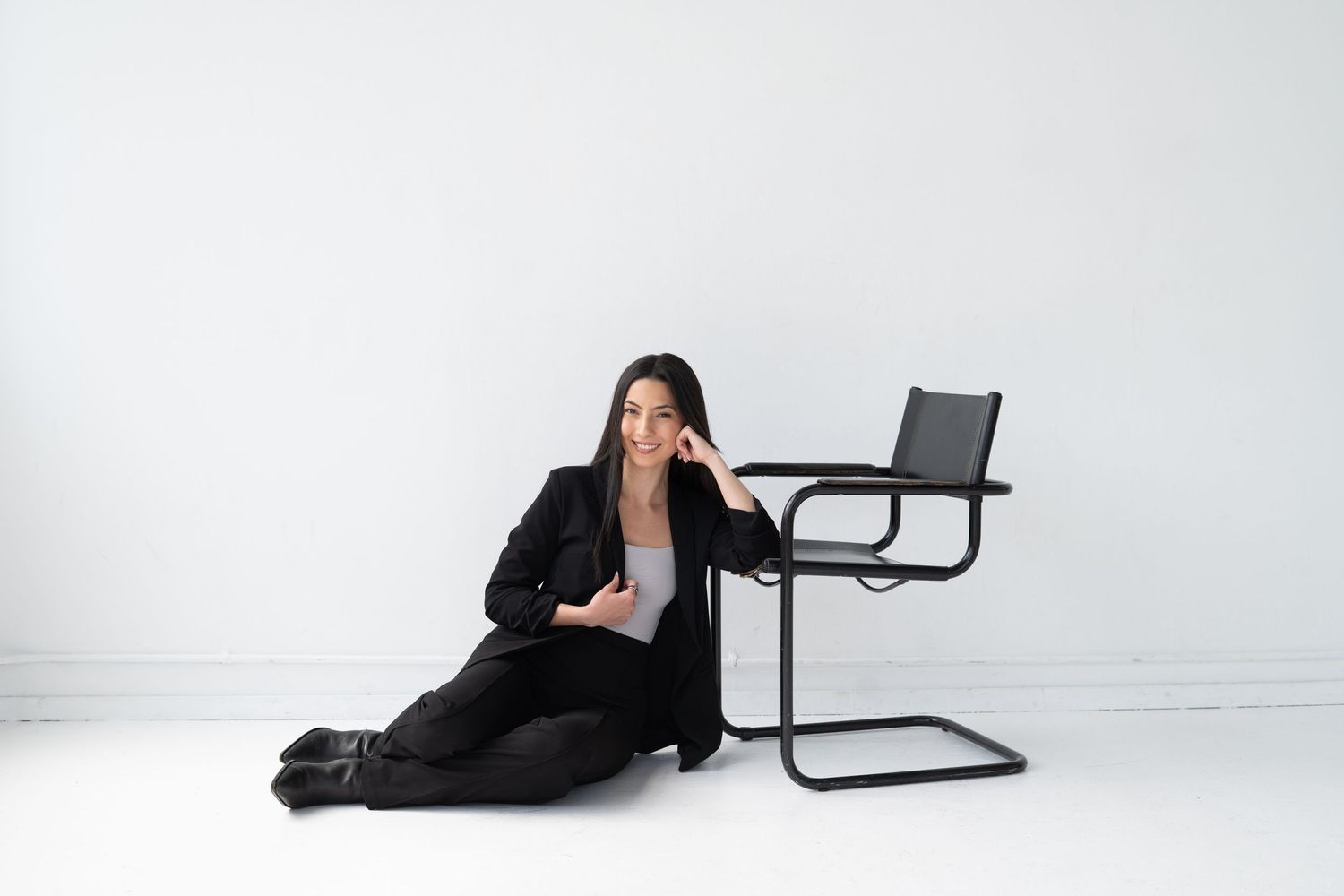 Artistic photo series showing person lounging with black chair against white backdrop.