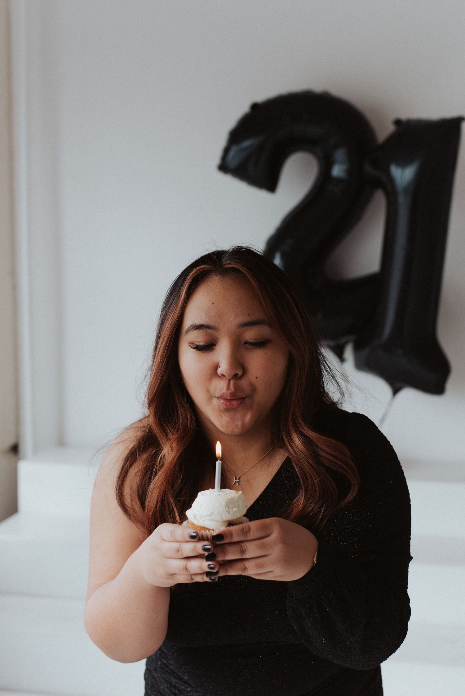 A series of photos showing someone enjoying a birthday cupcake with a single candle against a dark background.