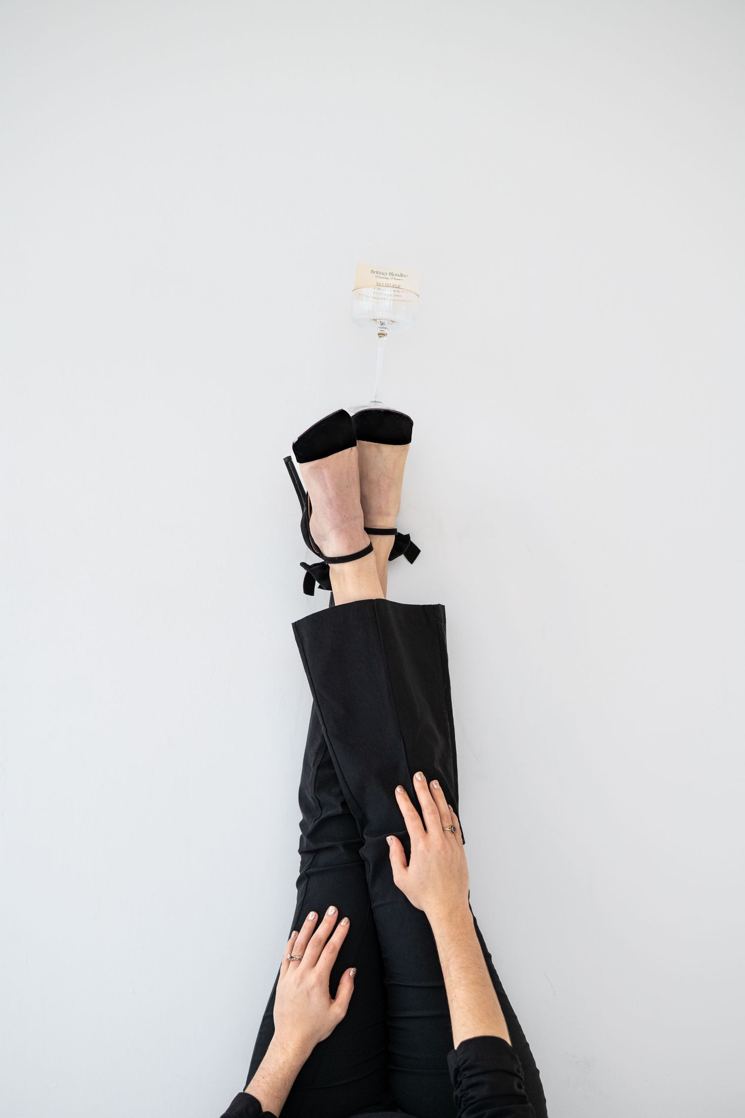 Series of black pants being pulled up against white background showing styling process.