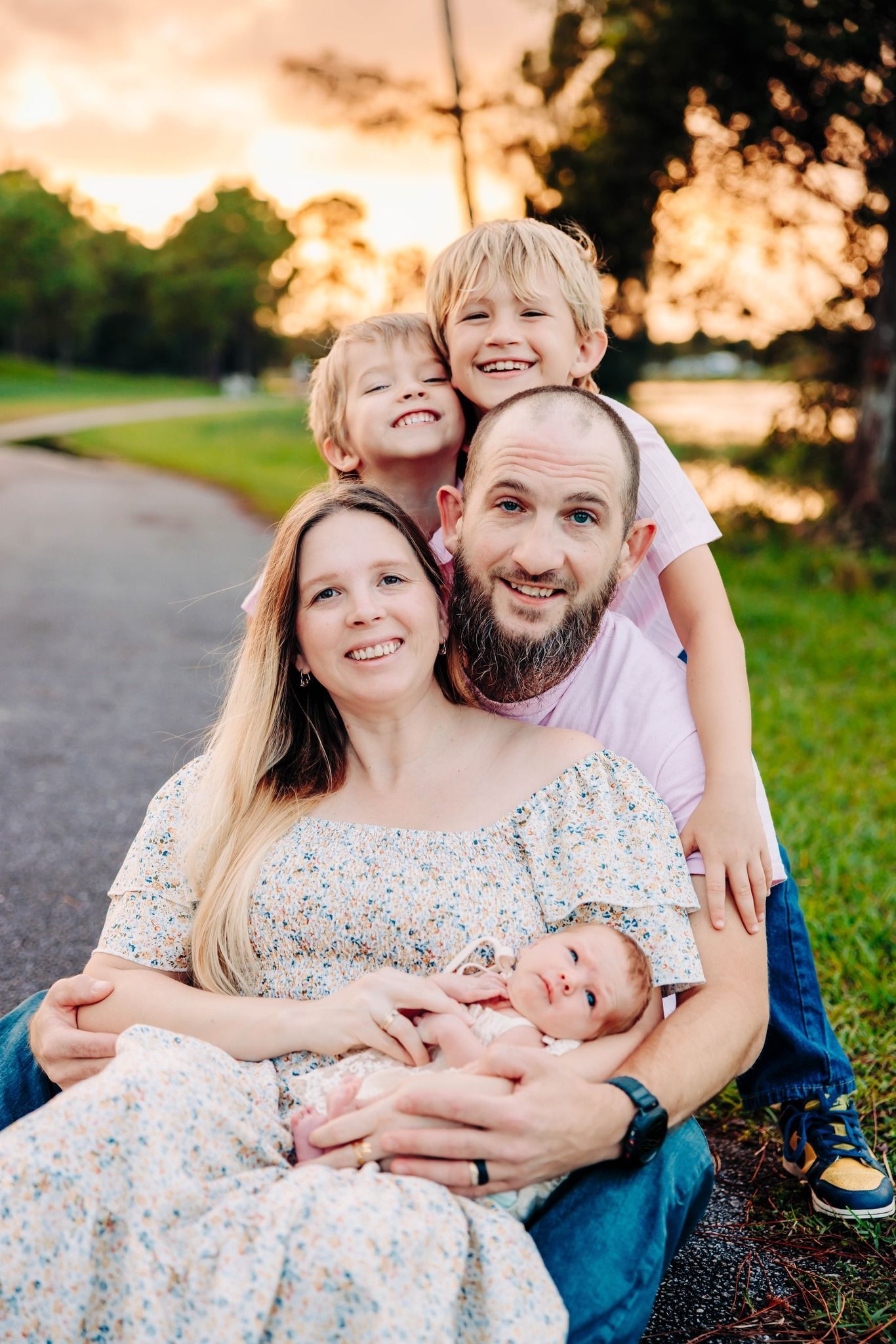Family group poses together on path during golden sunset at Okeeheelee park.