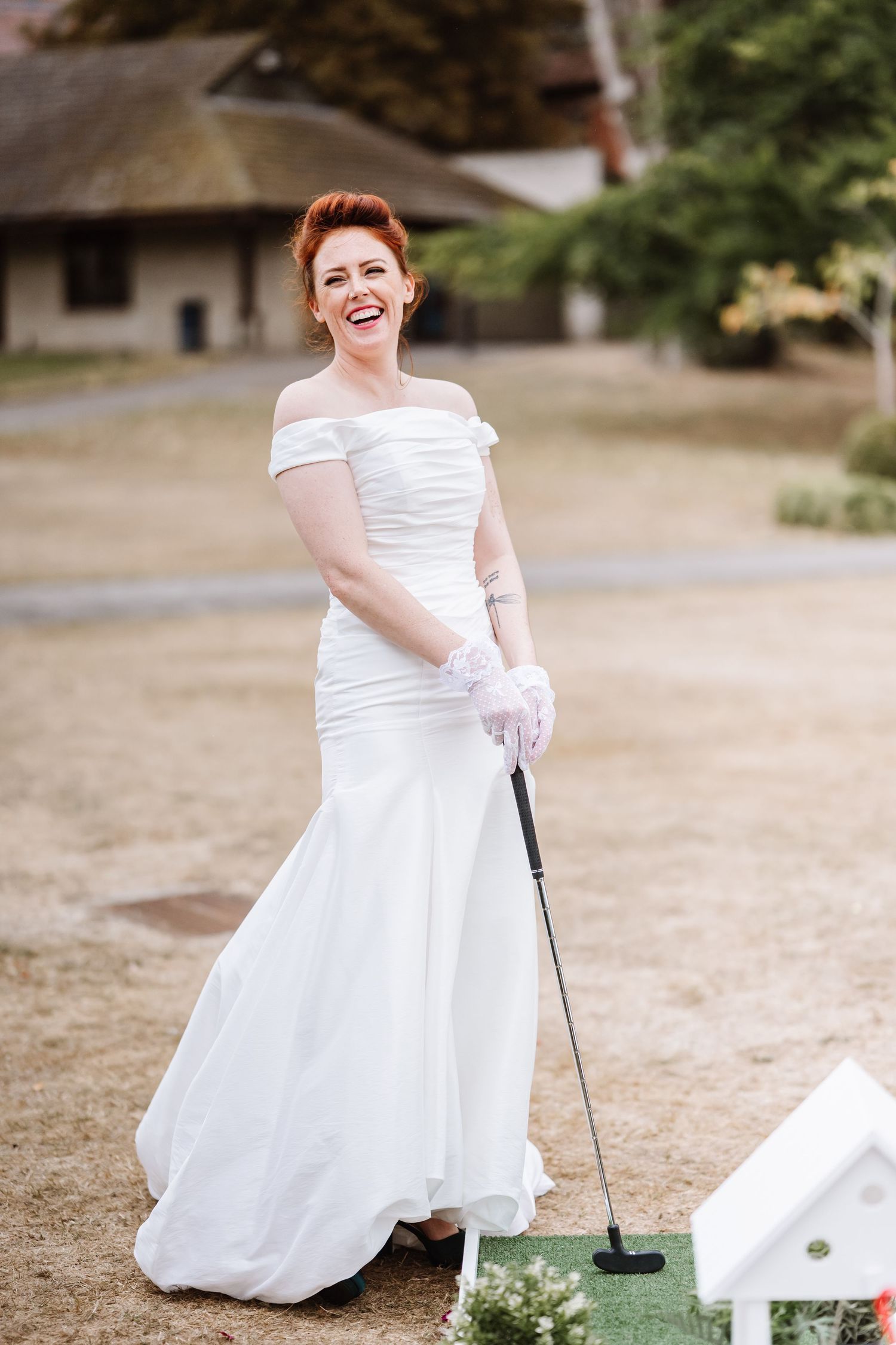 Weymouth wedding photographer. Bride plays mini golf at Dorset wedding venue Clayesmore school. Wedding garden game hire from The Hire Barn