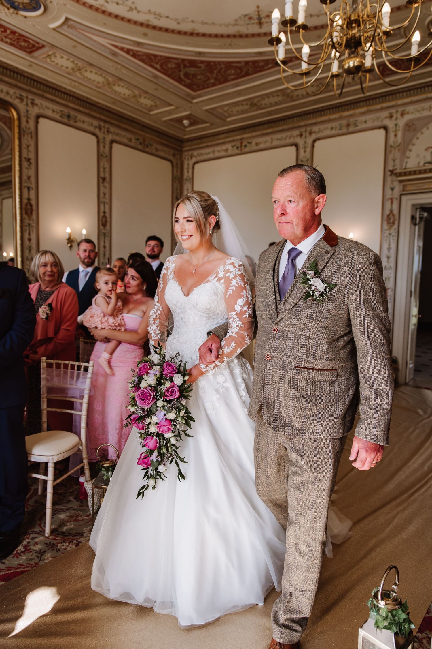 Bride and her father walk the aisle at a Kingston Maurward Estate a wedding venue Dorchester from a candid wedding photographer Weymouth