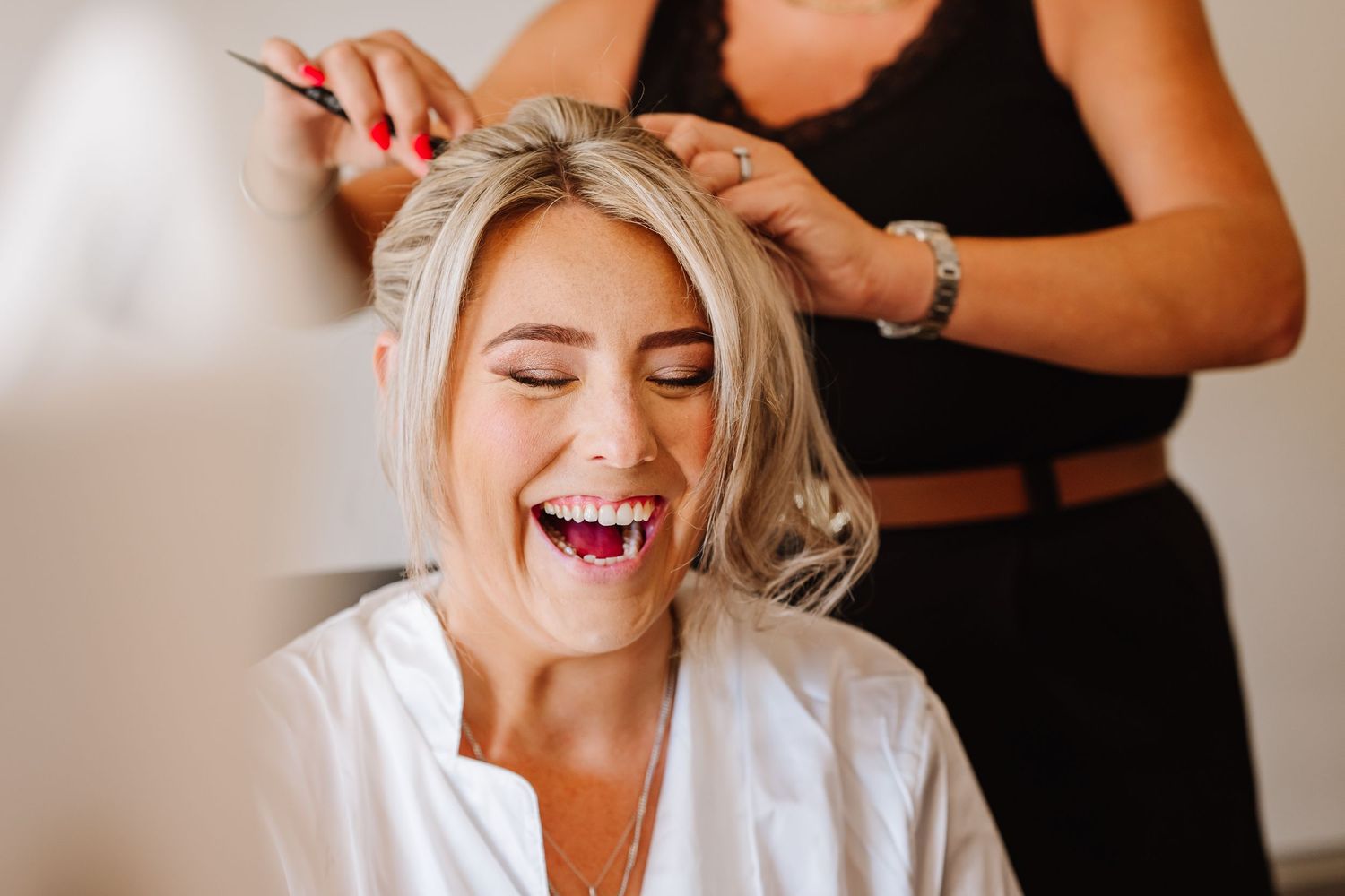 Bride naturally laughs during bridal prep. Candid wedding photographer based in Weymouth, Dorset