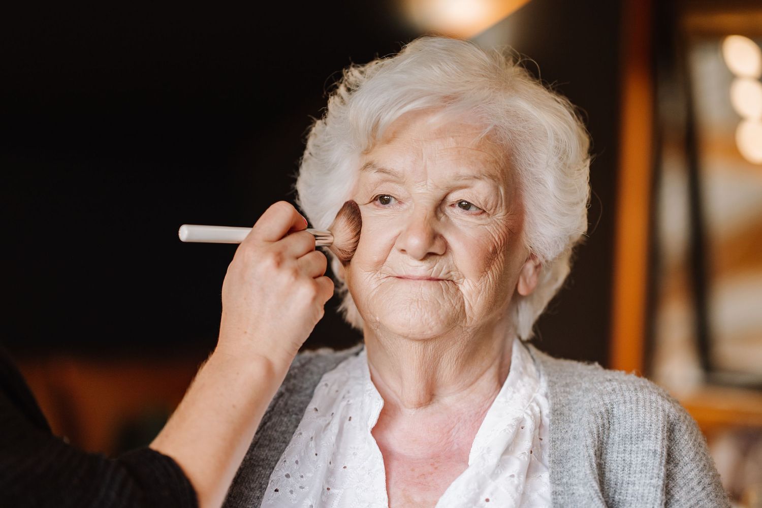Nan gets makeup done during bridal preparations at the Waterside Country Barn and Mill lakeside wedding venue near Taunton