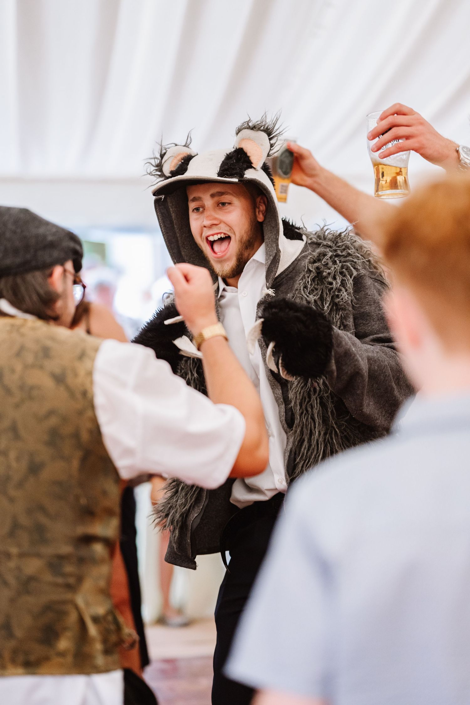 Guest dressed as badger dances Dorset Festival barn wedding at Cerne Abbas Brewery. Candid photos from a relaxed Dorset wedding photographer