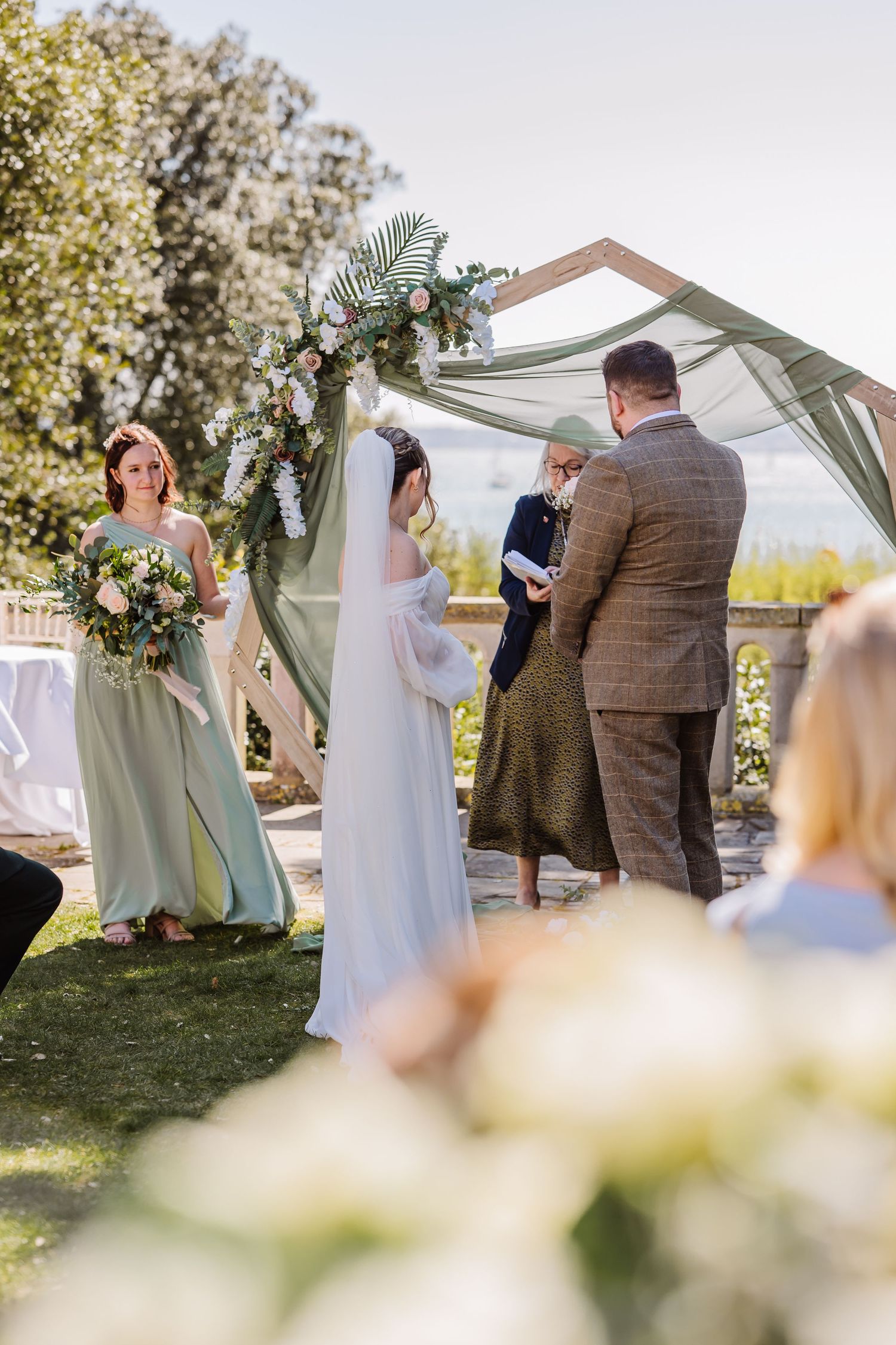 Outdoor wedding venue The Alverbank, near Portsmouth. Archway. Sage green bridesmaid dress. Hampshire candid wedding photographer