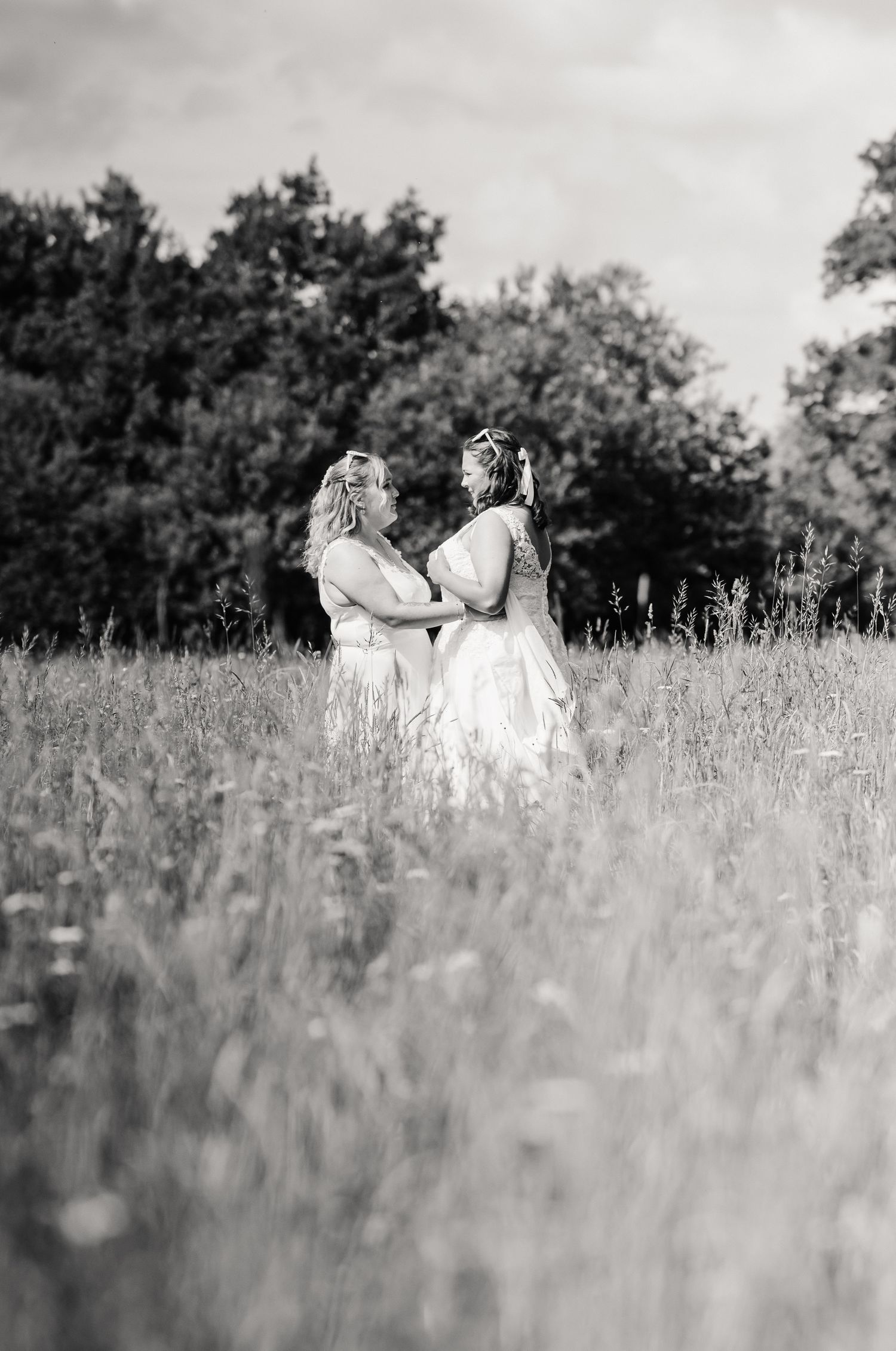 Weymouth wedding photographer. LGBTQ+ Dorset wedding.  black and white sequence of  two brides together in a tall grass meadow.