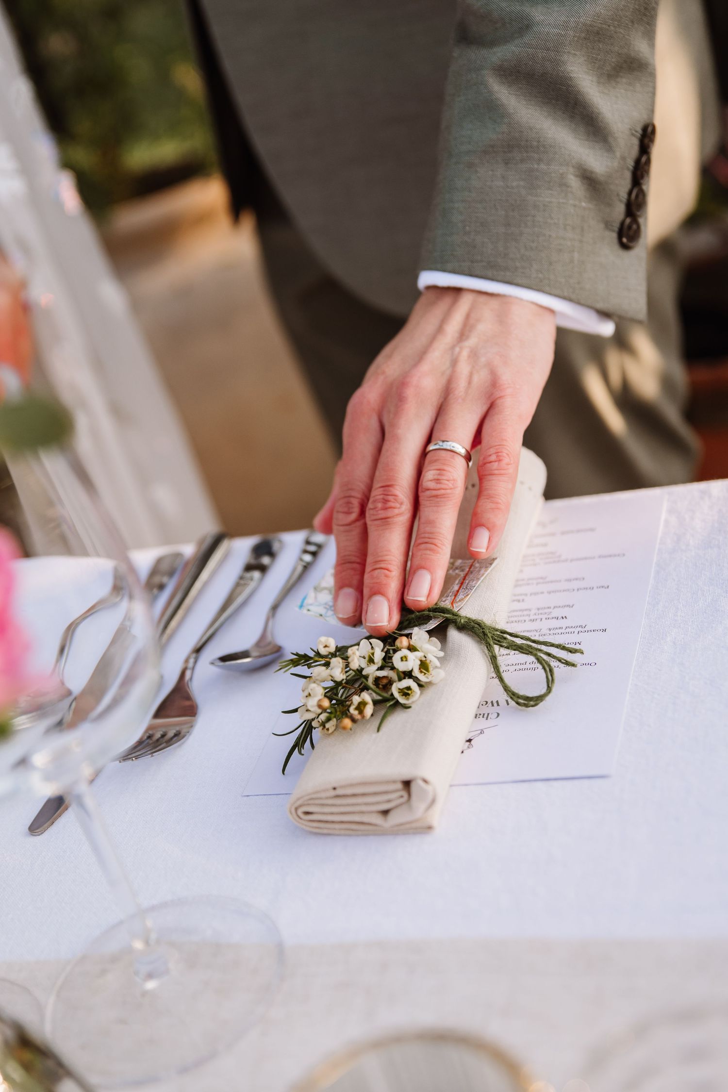 Bride and groom admire a floral-decorated wedding reception table inside a sunlit glass greenhouse venue. The Cornish Place wedding venue