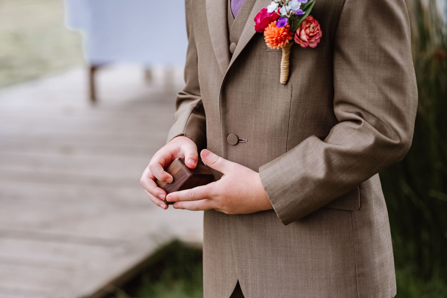 Ring bearer hold the rings at the Waterside Country Barn and Mill lakeside wedding venue near Taunton. Relaxed Somerset Wedding photographer