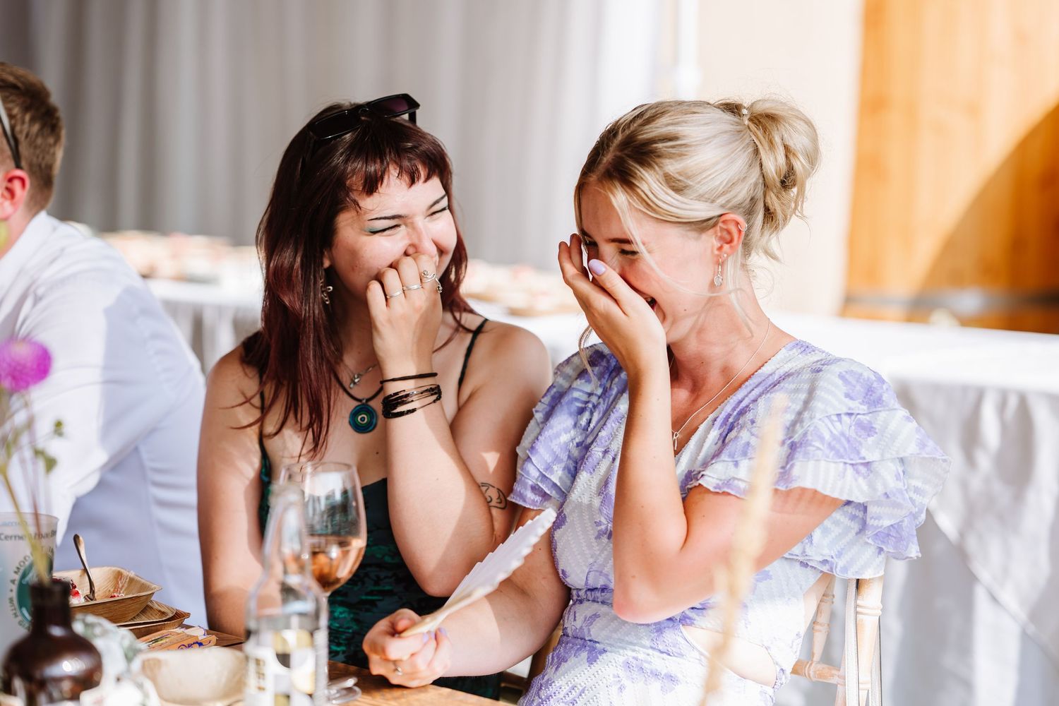 Guests laugh at Dorset Festival barn wedding at Cerne Abbas Brewery. Candid photos from a relaxed Dorset wedding photographer