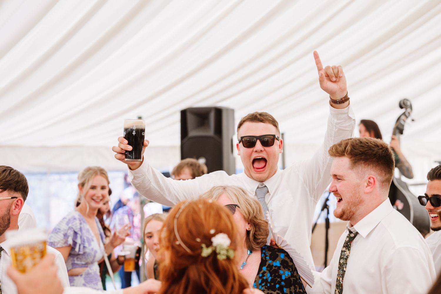 Guests dance at Dorset Festival barn wedding at Cerne Abbas Brewery. Candid photos from a relaxed Dorset wedding photographer