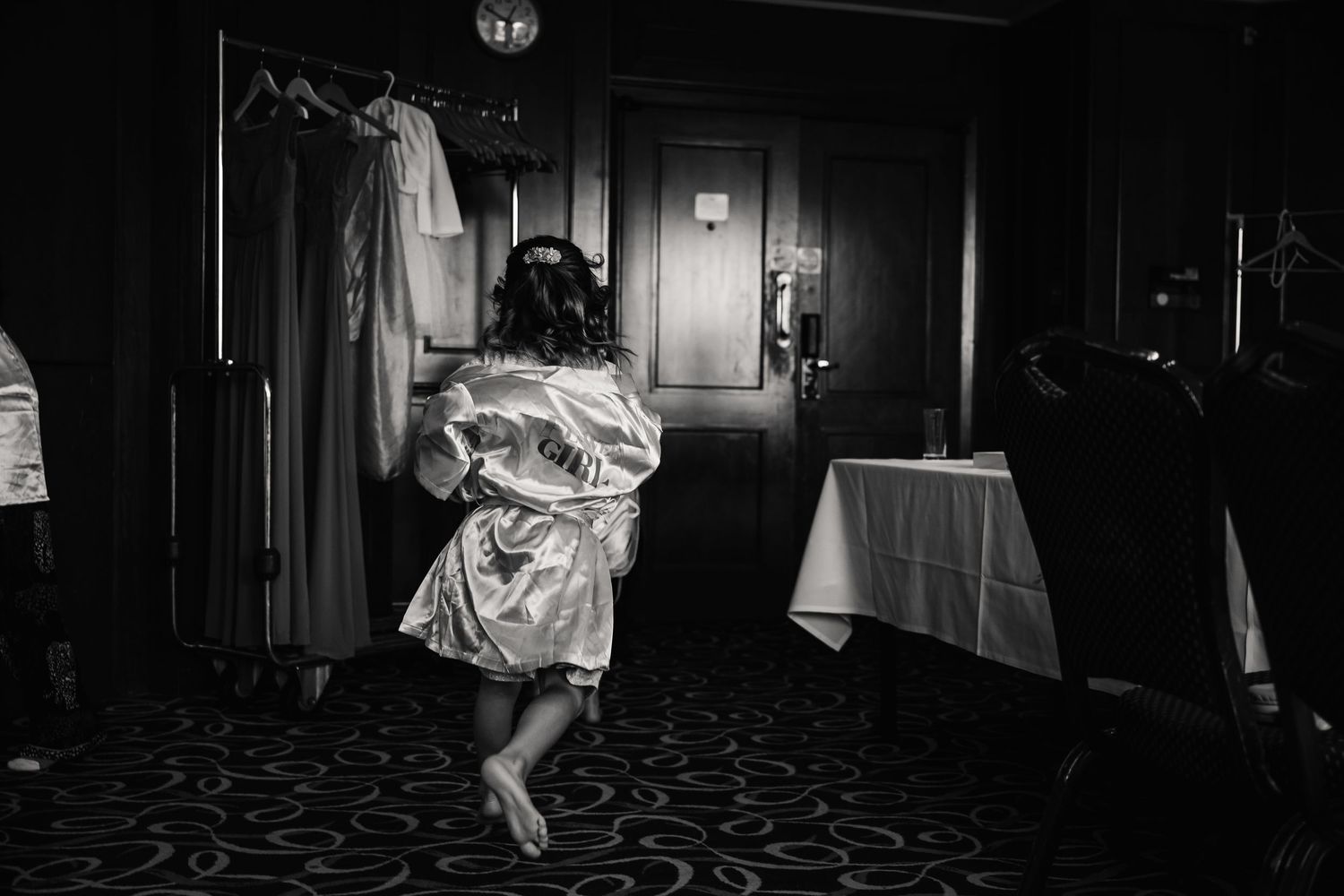 Black and white photo of a bride in a satin robe dancing joyfully in a hotel room before her wedding Southampton Wedding venue