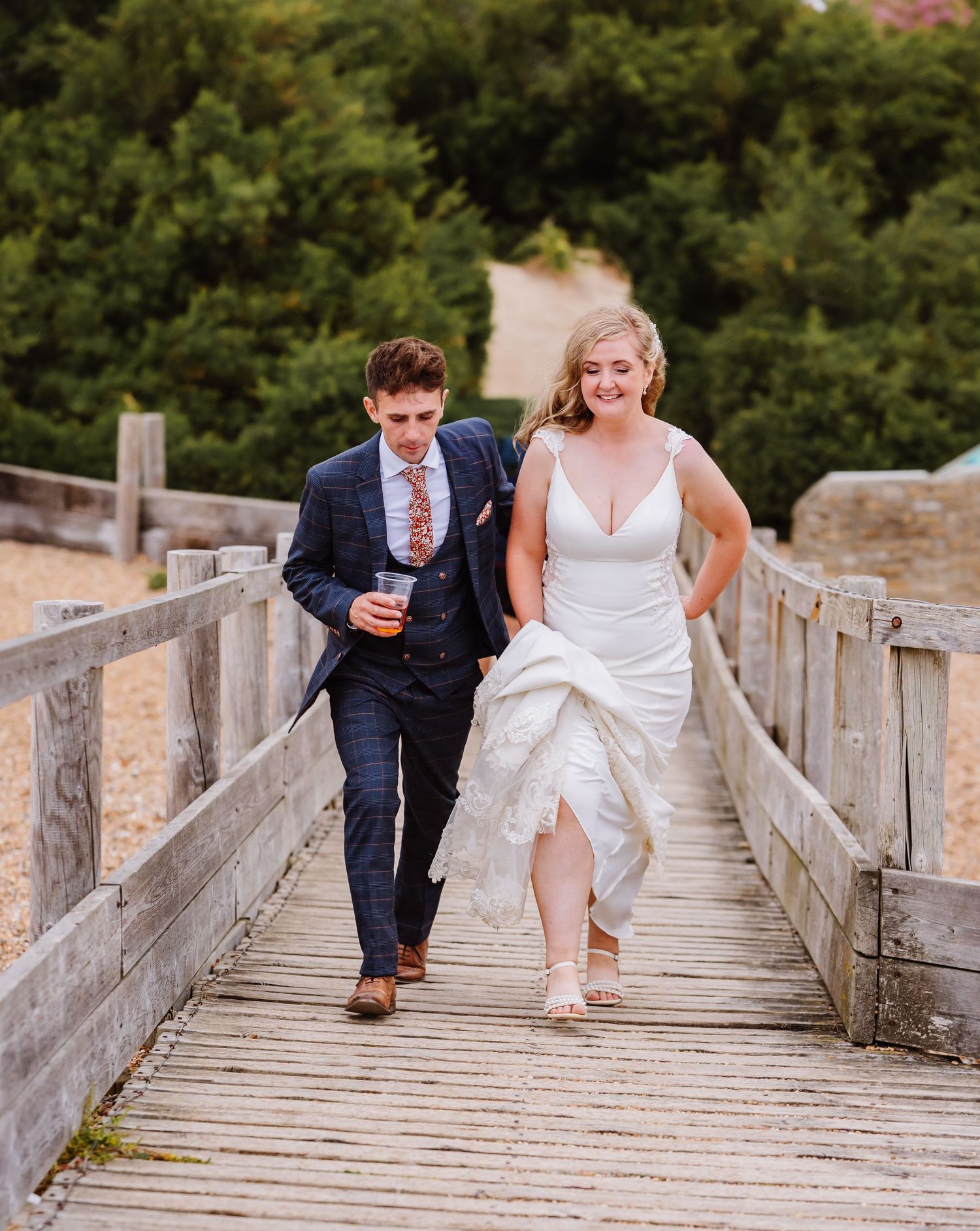 Bride and groom on Chesil Beach following their wedding at Abbotsbury Subtropical Gardens. Candid wedding photographer based in Weymouth