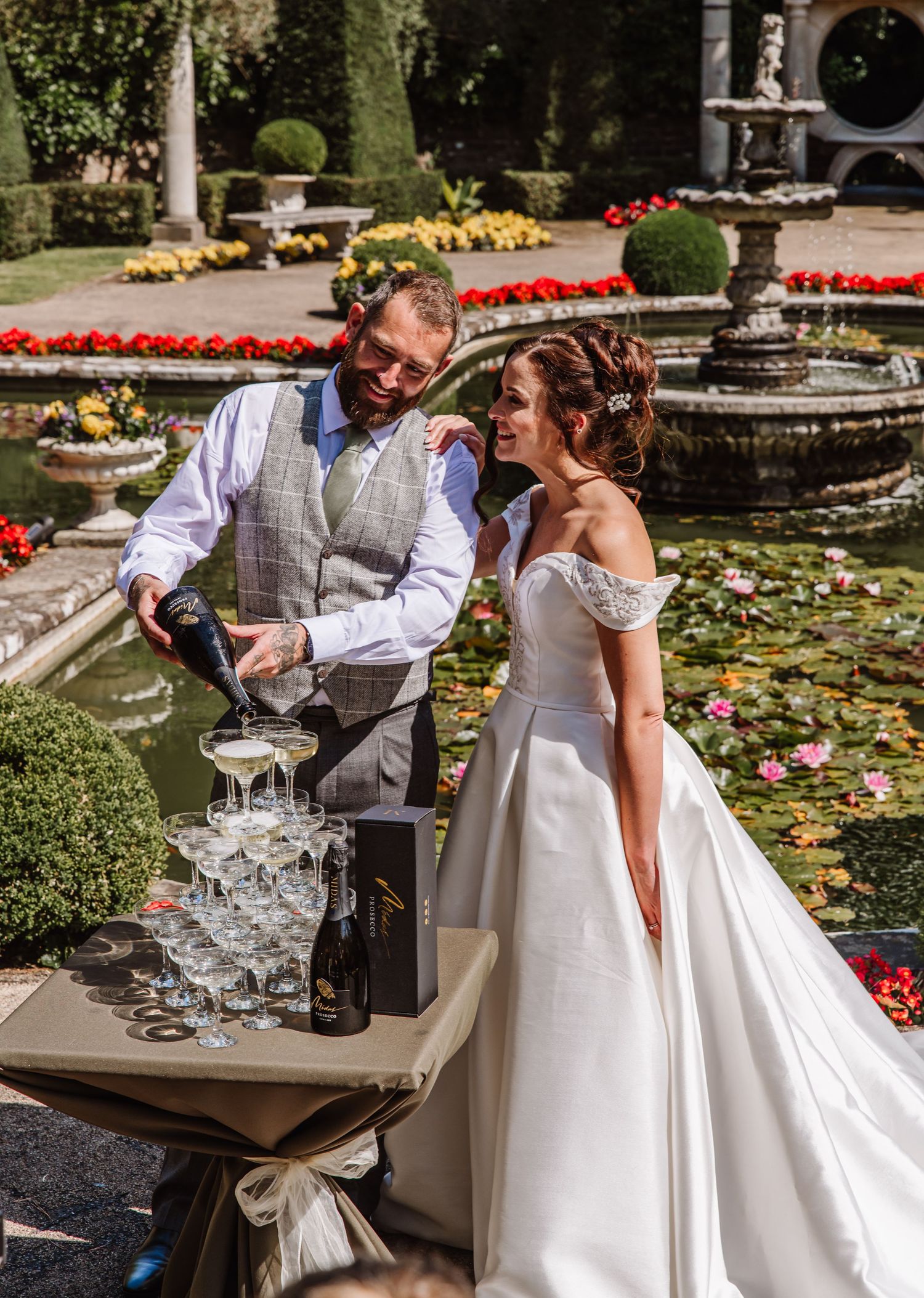 Bride and Groom pour champagne on a Champagne tower at the Italian Villa, Compton Acres Poole from a Dorset candid wedding photographer