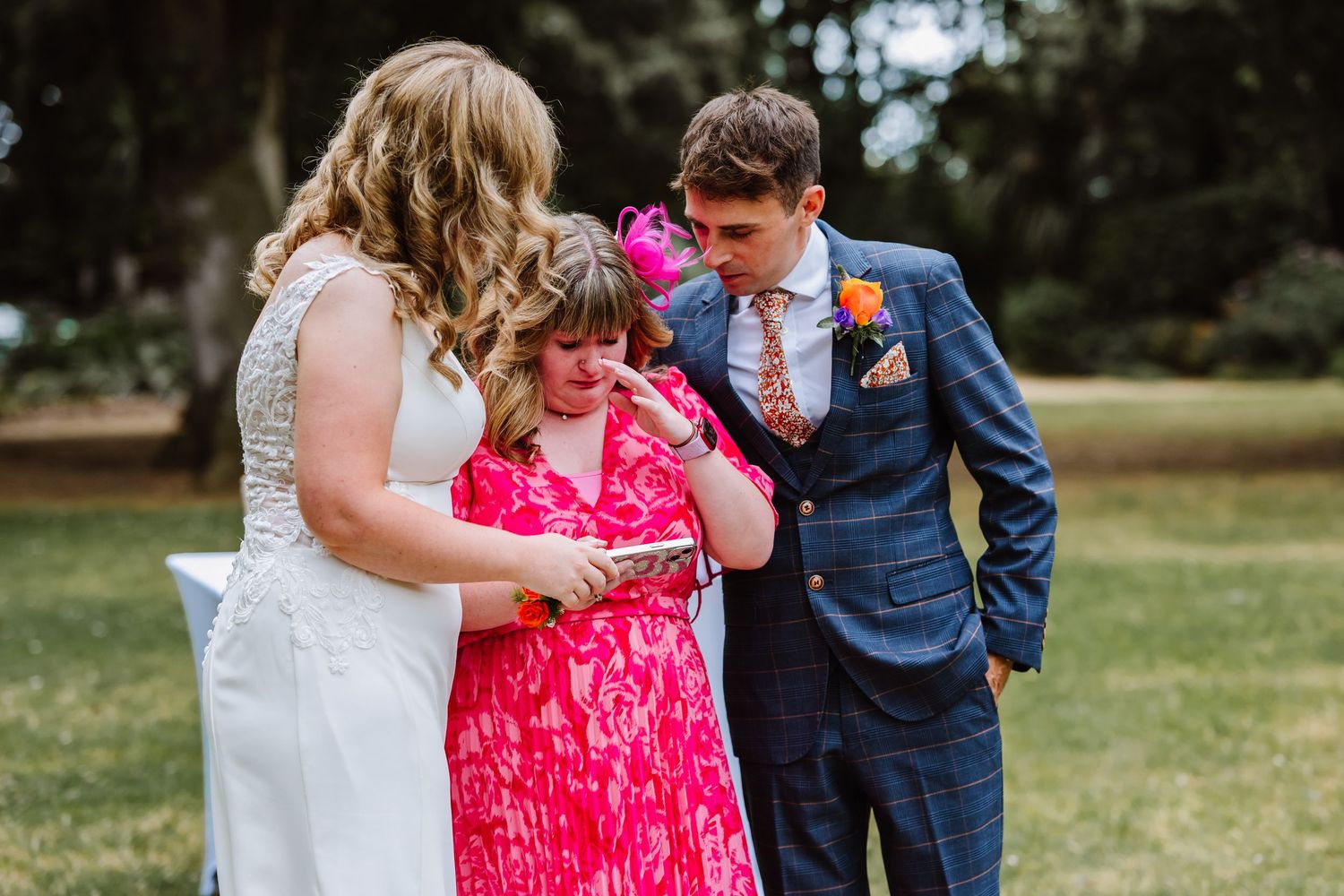 Abbotsbury Gardens wedding. Outdoor wedding venue in Dorset, Bride and Groom hug sister during speech. Candid Weymouth wedding photographer