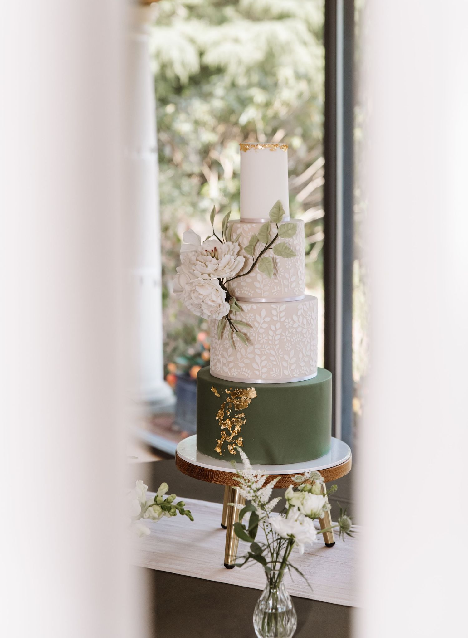 Green and ivory wedding cake with gold leaf and ivory flowers. Italian Villa, Compton Acres Poole from a Dorset candid wedding photographer