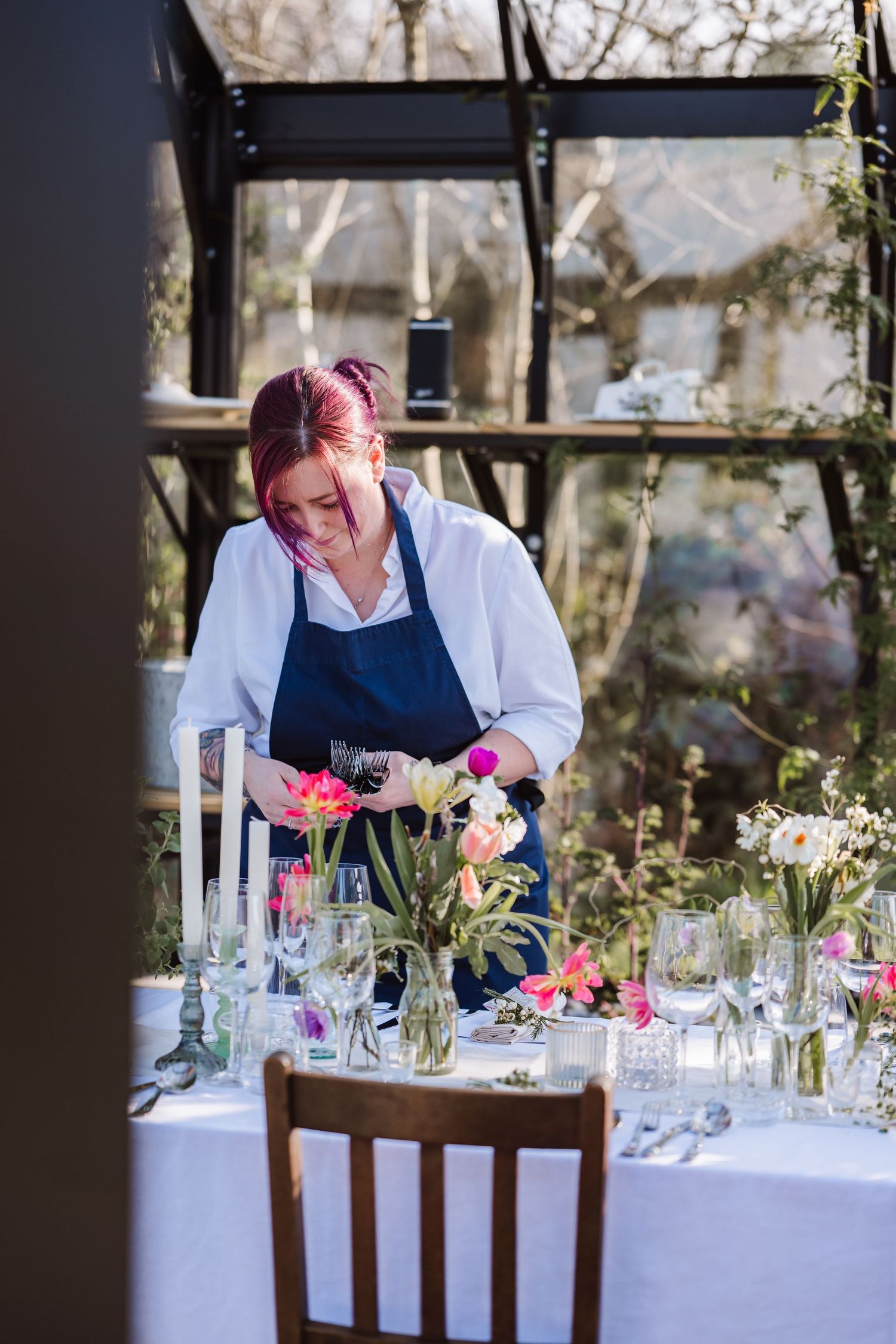 Floral-decorated reception table inside a sunlit glass greenhouse venue. The Cornish Place wedding venue. Unusual wedding venues, Cornwall