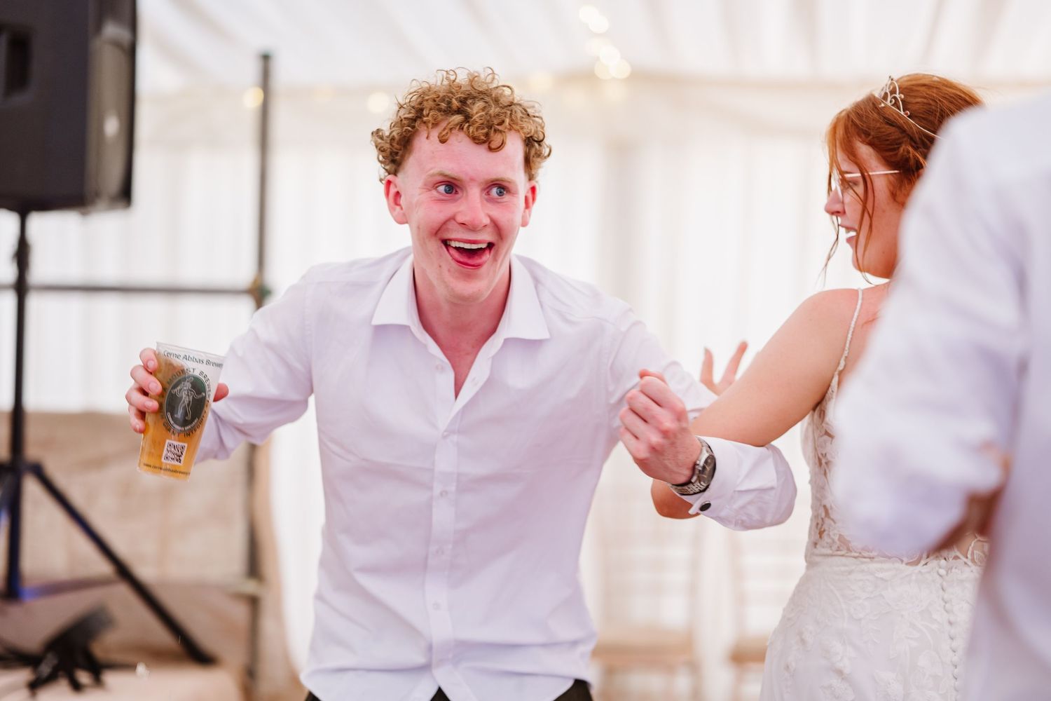 Guest dances to local band at Dorset Festival barn wedding at Cerne Abbas Brewery. Candid photos from a relaxed Dorset wedding photographer