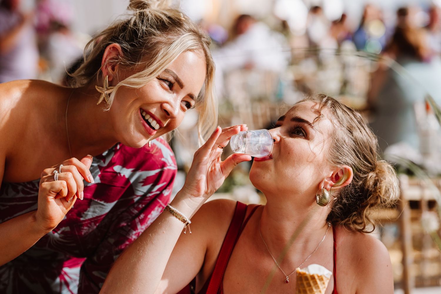 Guests drink shots at Dorset Festival barn wedding at Cerne Abbas Brewery. Candid photos from a relaxed Dorset wedding photographer