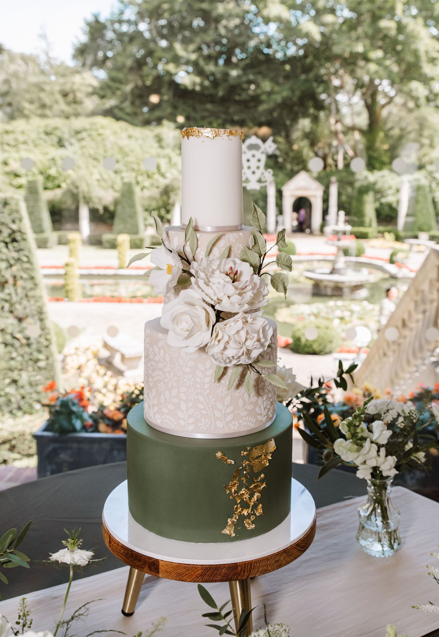 Green and ivory wedding cake with gold leaf and ivory flowers. Italian Villa, Compton Acres Poole from a Dorset candid wedding photographer
