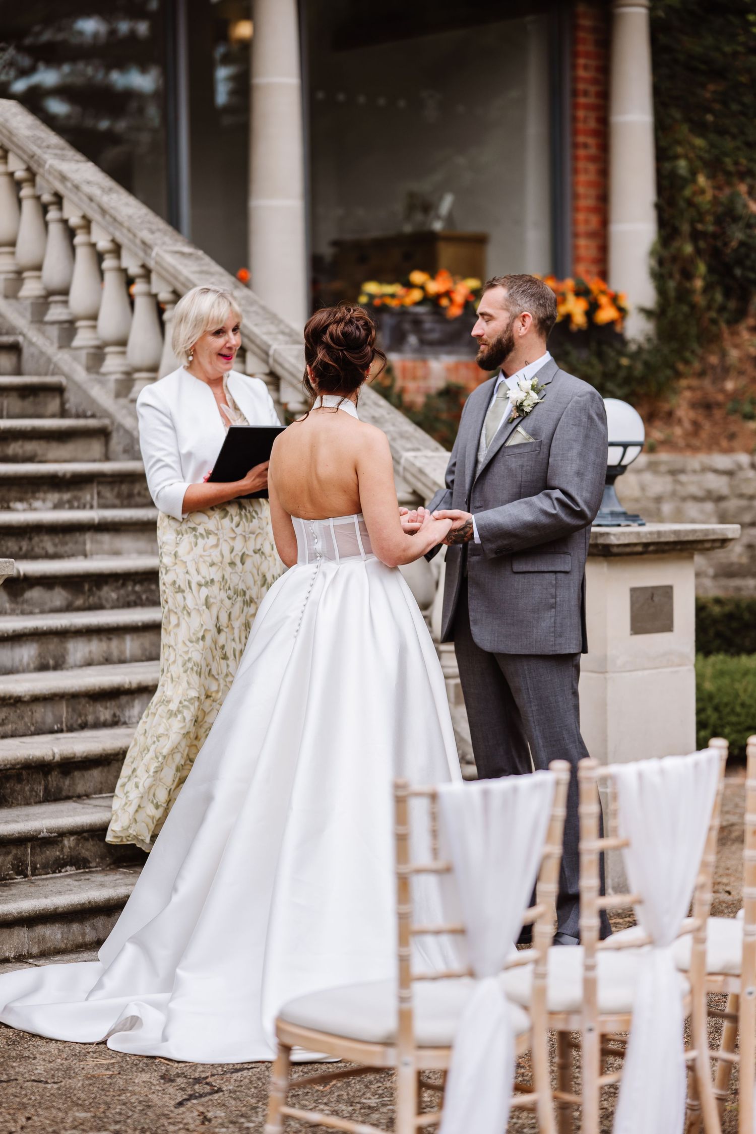 Wedding at the Italian Villa, Compton Acres. Bride in a white gown and groom in gray suit during an outdoor ceremony. Wedding photographer