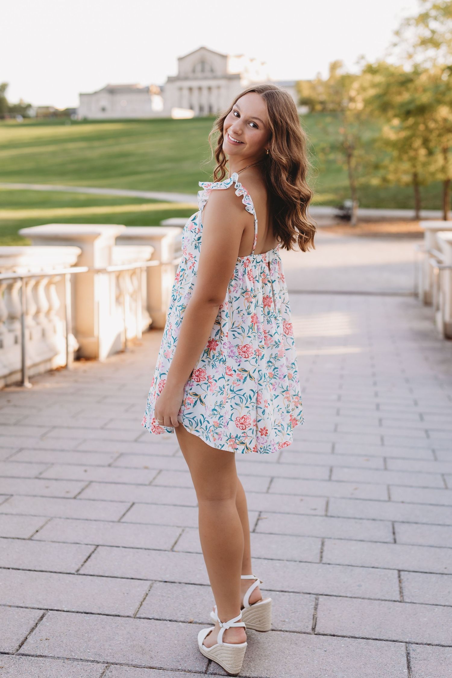 senior girl on stone bride with st Louis art museum behind her art hill forest park