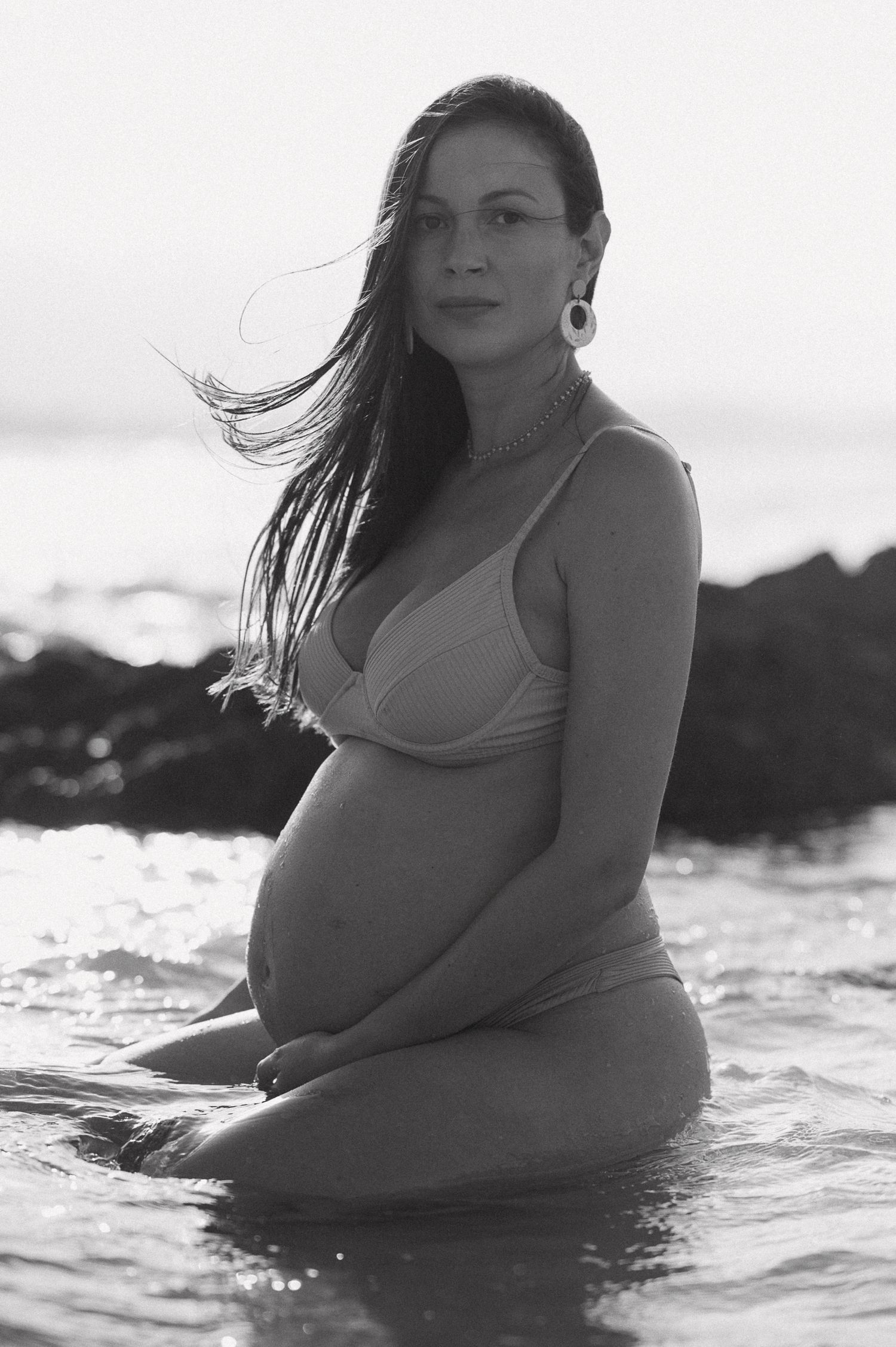 Black and white portrait of someone floating peacefully in ocean water.