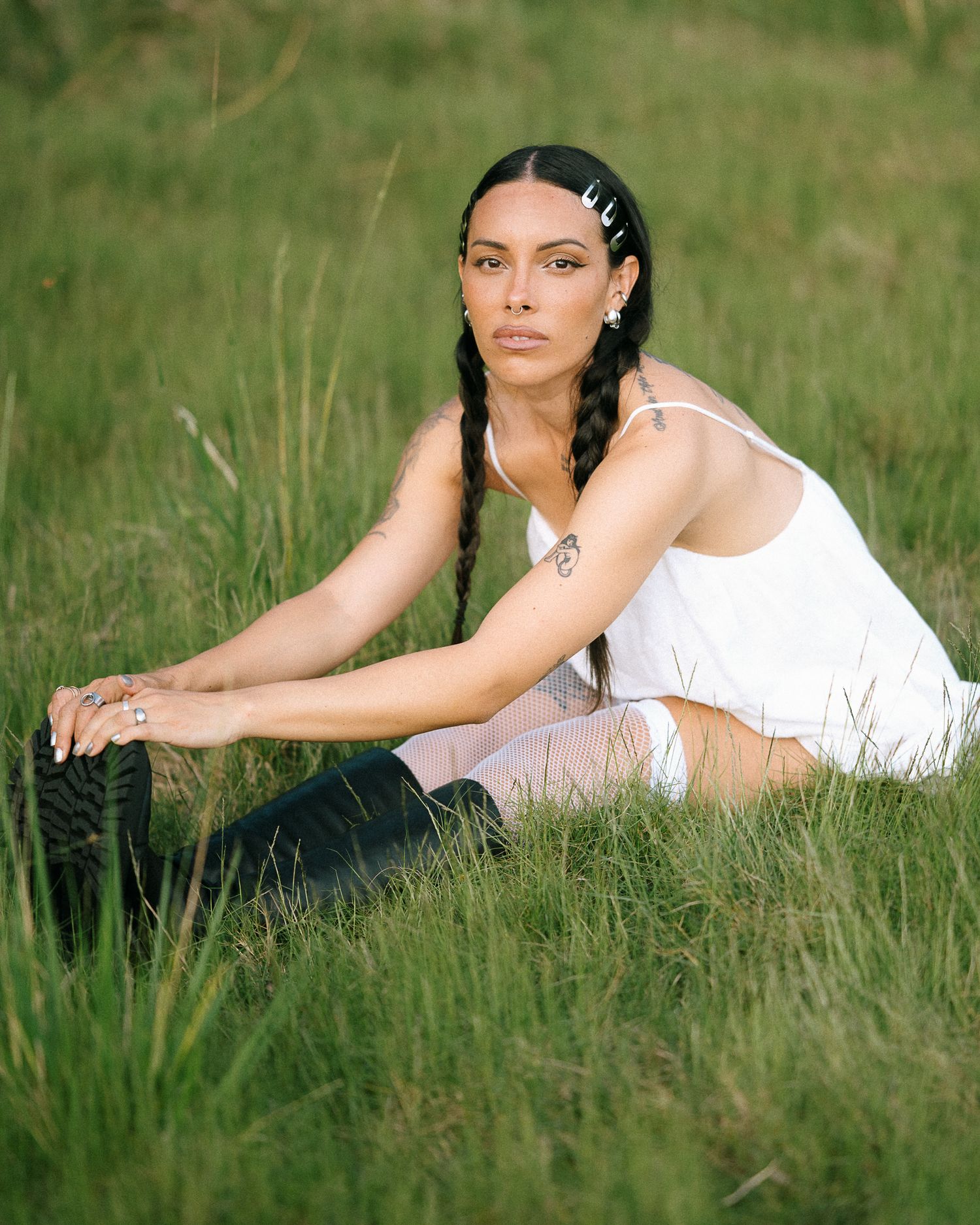A peaceful summer portrait in a grassy field wearing a white top and hair clips.