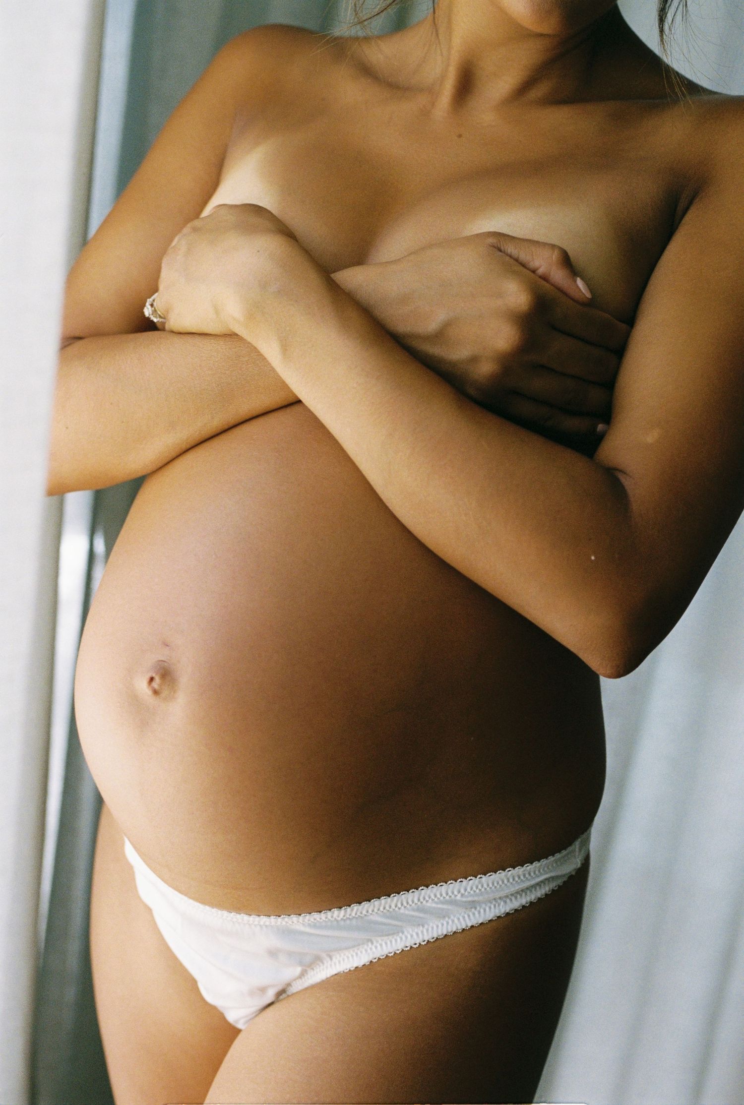 Intimate maternity photos showing pregnancy progression in white lingerie.