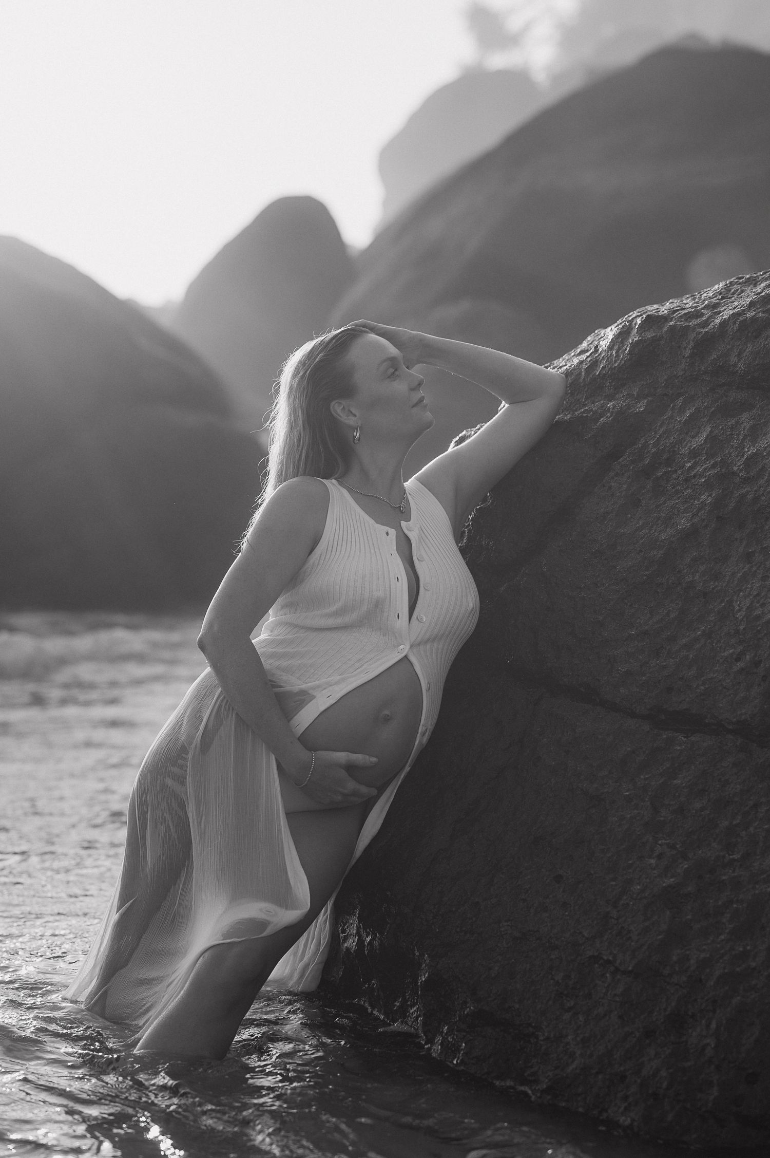 Artistic black and white beach portrait with dramatic rocks and waves.