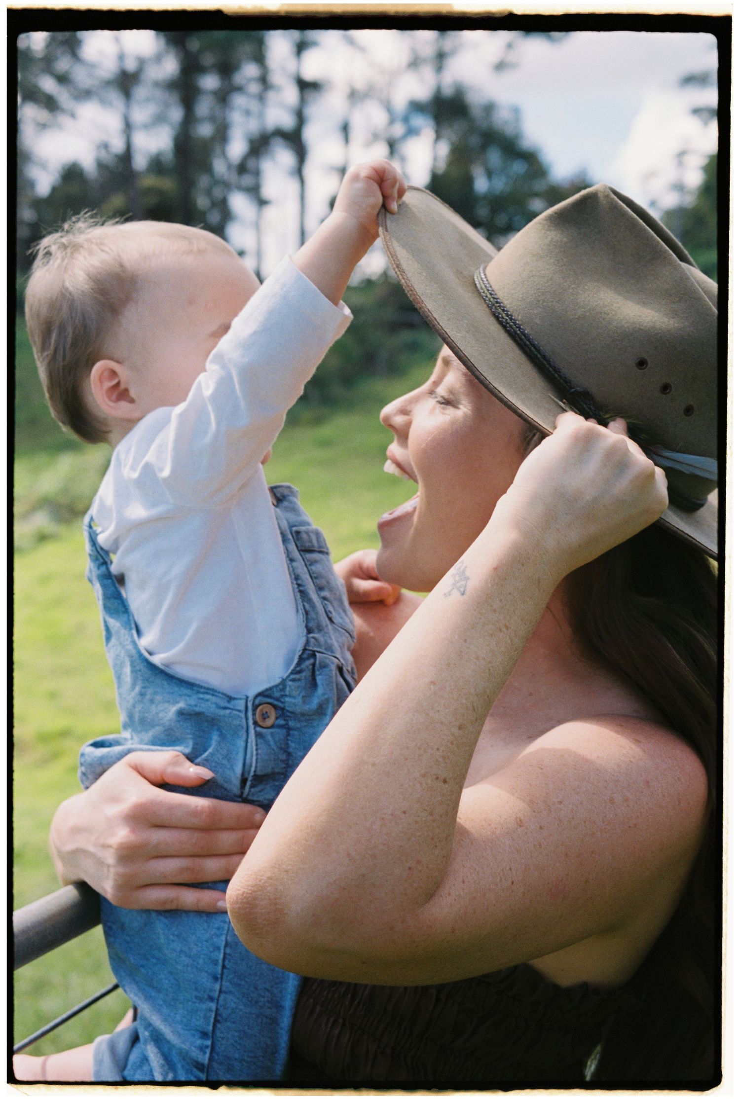 Parent and baby sharing a joyful moment outdoors.