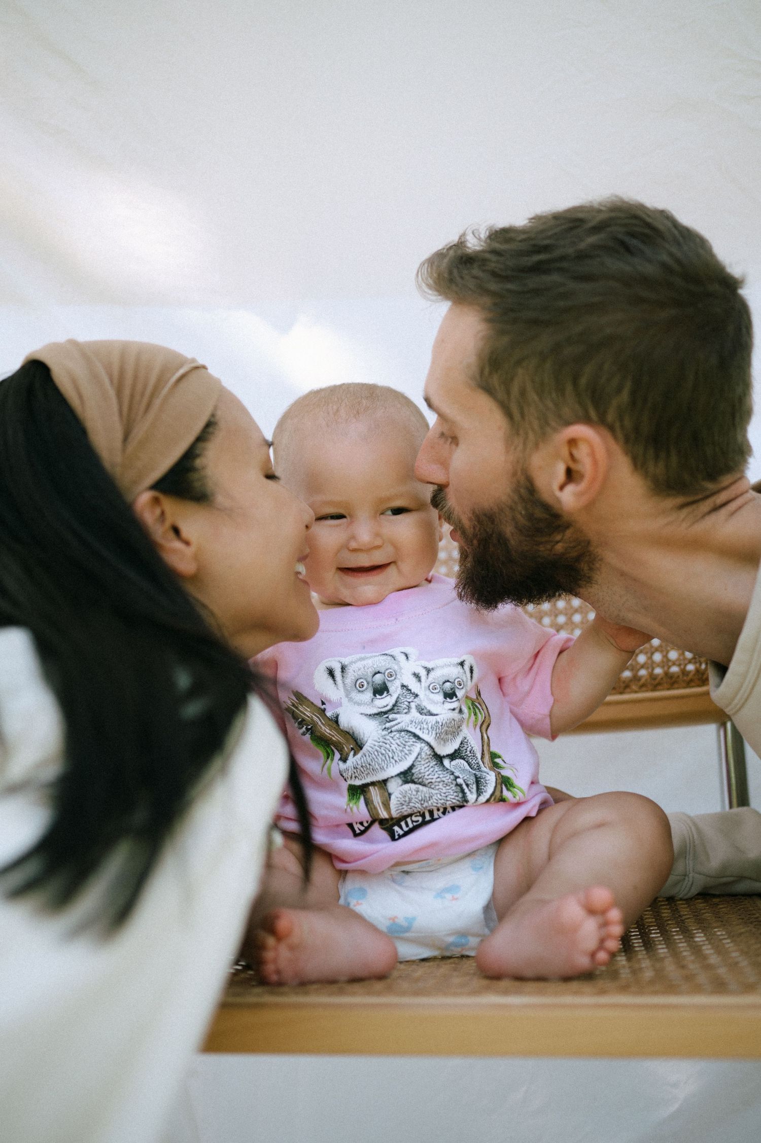 Parents share an intimate moment with their baby lying between them.