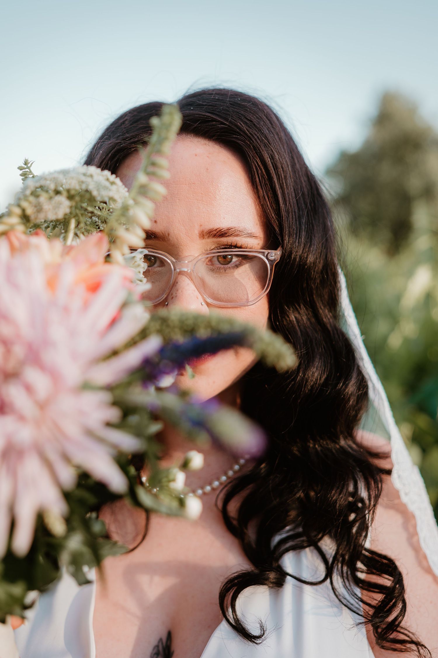 A bouquet of pink and purple flowers frames a close-up shot with soft natural lighting.