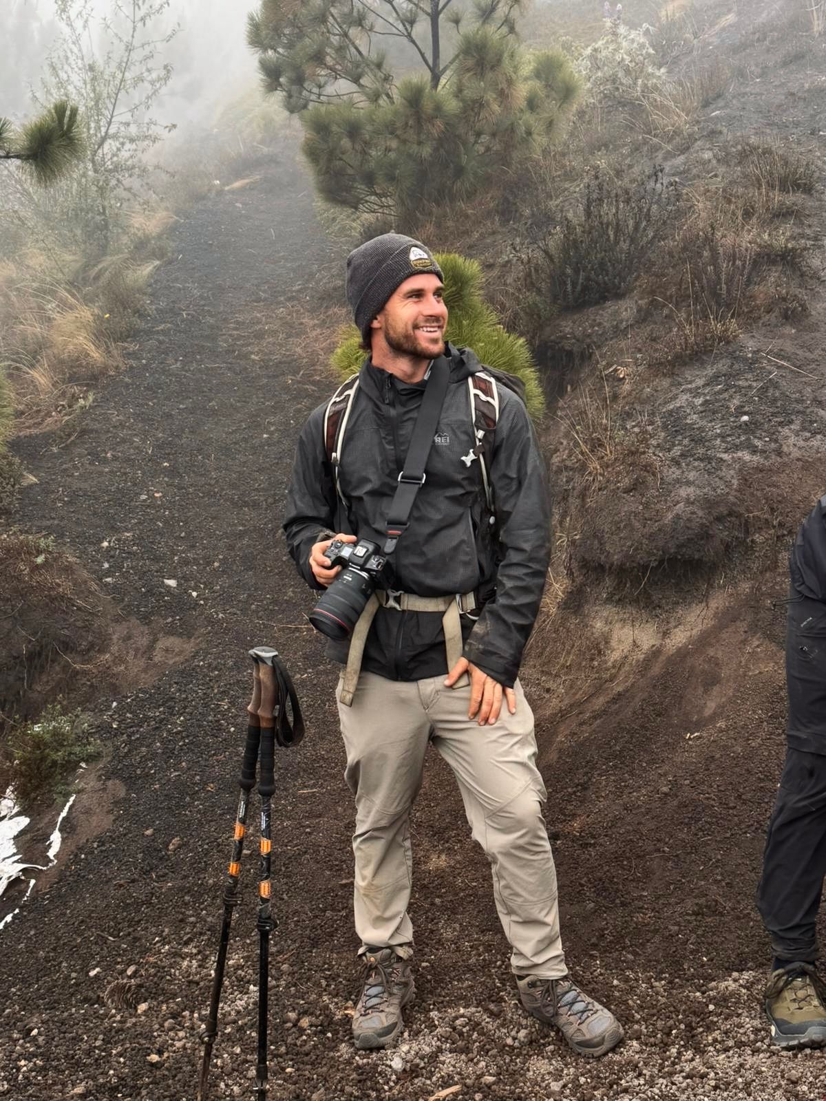 Hiking gear and equipment displayed on rocky volcanic terrain.